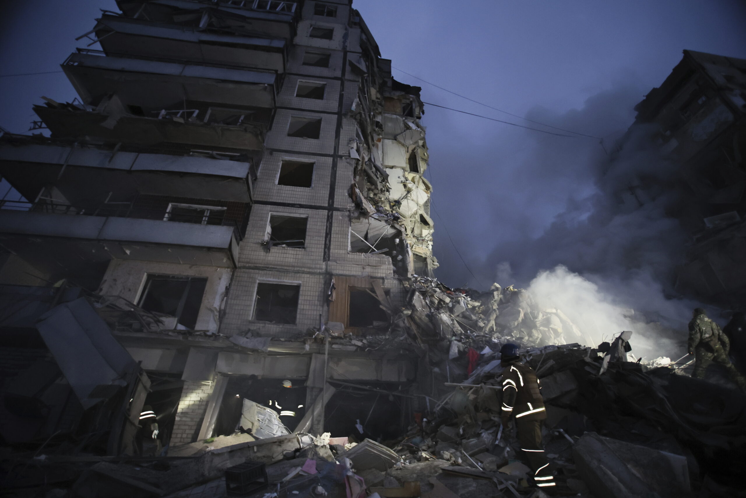 Emergency workers clear the rubble after a Russian rocket hit a multistory building leaving many people under debris in Dnipro, Ukraine, Saturday, Jan. 14, 2023. (AP Photo/Roman Chop)