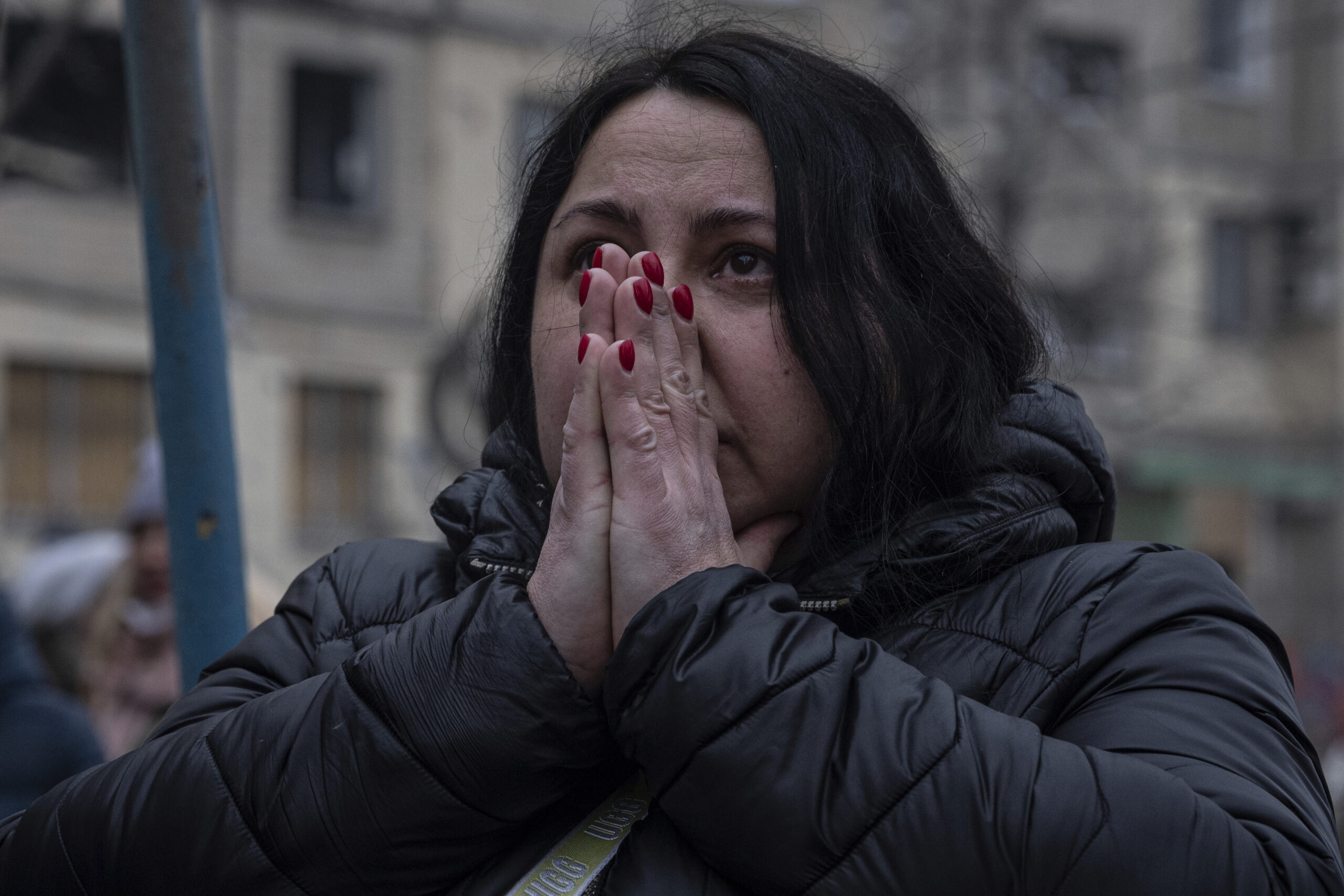 A woman reacts looking at the damage caused to an apartment building that was destroyed in a Russian rocket attack at a residential neighbourhood in the southeastern city of Dnipro, Ukraine, Sunday, Jan. 15, 2023. (AP Photo/Evgeniy Maloletka)