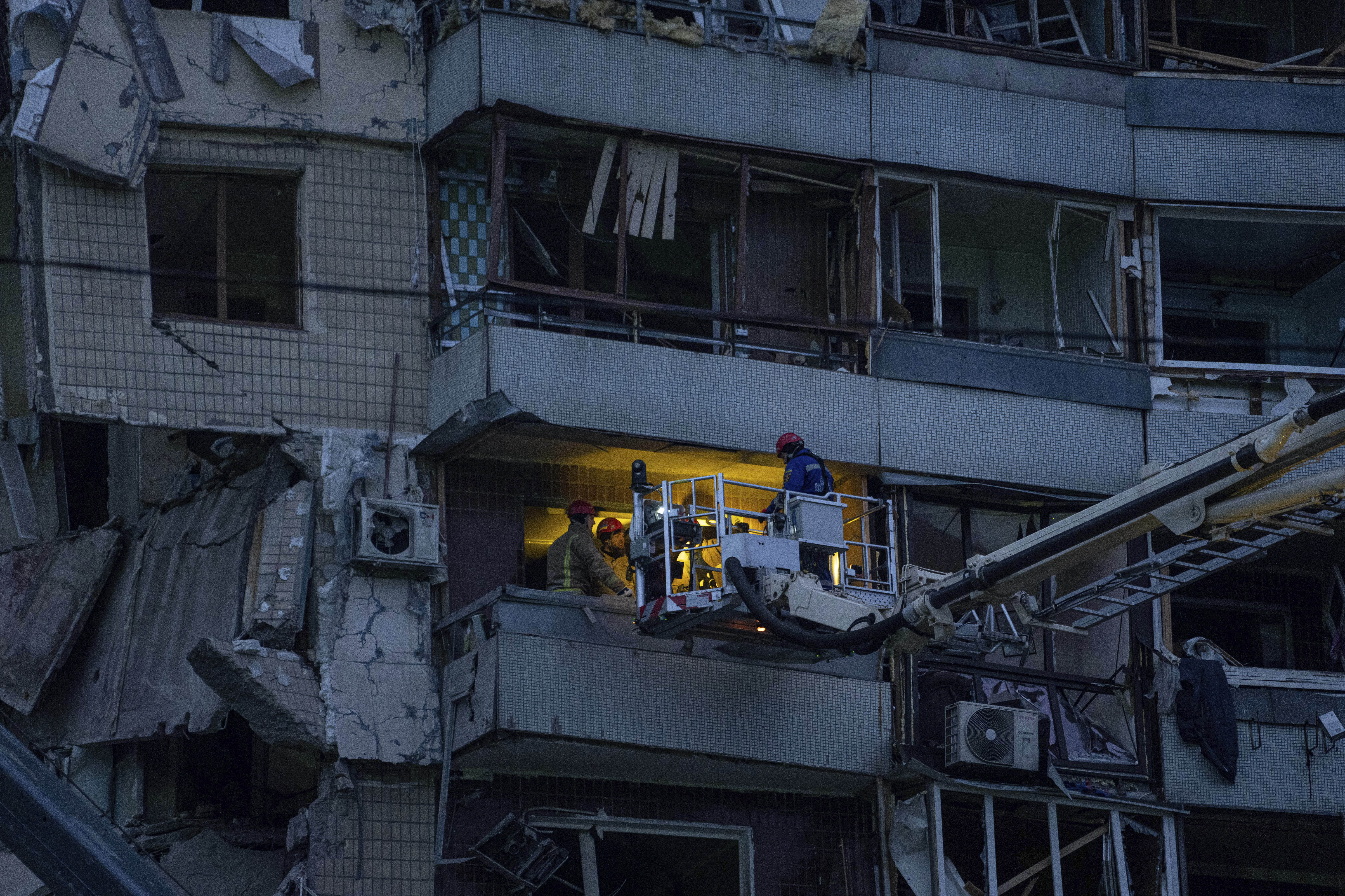 Rescue workers search for survivors in an apartment building that was destroyed in a Russian rocket attack at a residential neighbourhood in the southeastern city of Dnipro, Ukraine, Sunday, Jan. 15, 2023. (AP Photo/Evgeniy Maloletka)