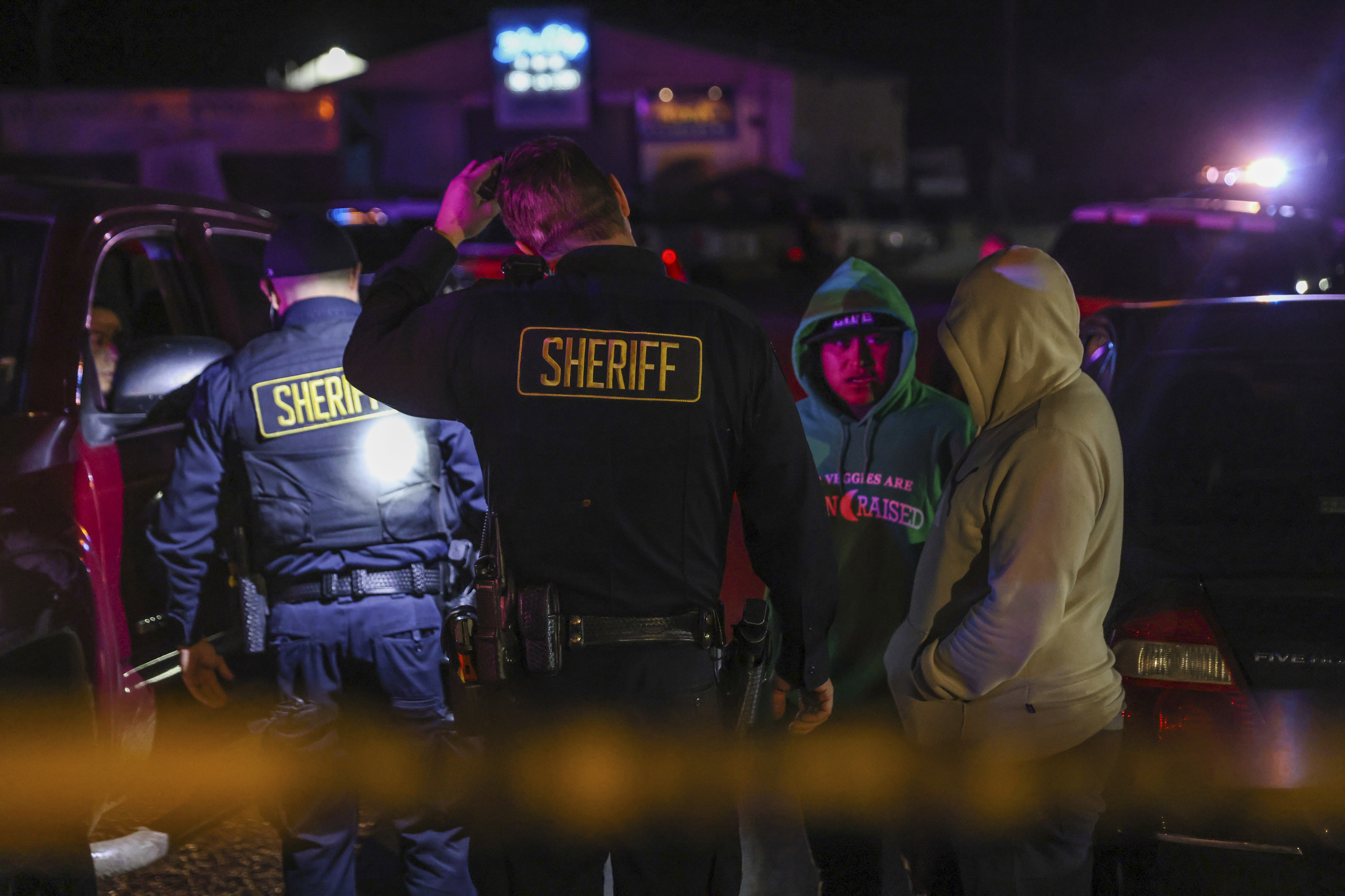 Sheriff's deputies talk with people at the scene of a deadly shooting where several fatalities occurred off state Highway 92 in Half Moon Bay, Calif., on Monday, Jan. 23, 2023. (Gabrielle Lurie/San Francisco Chronicle via AP)