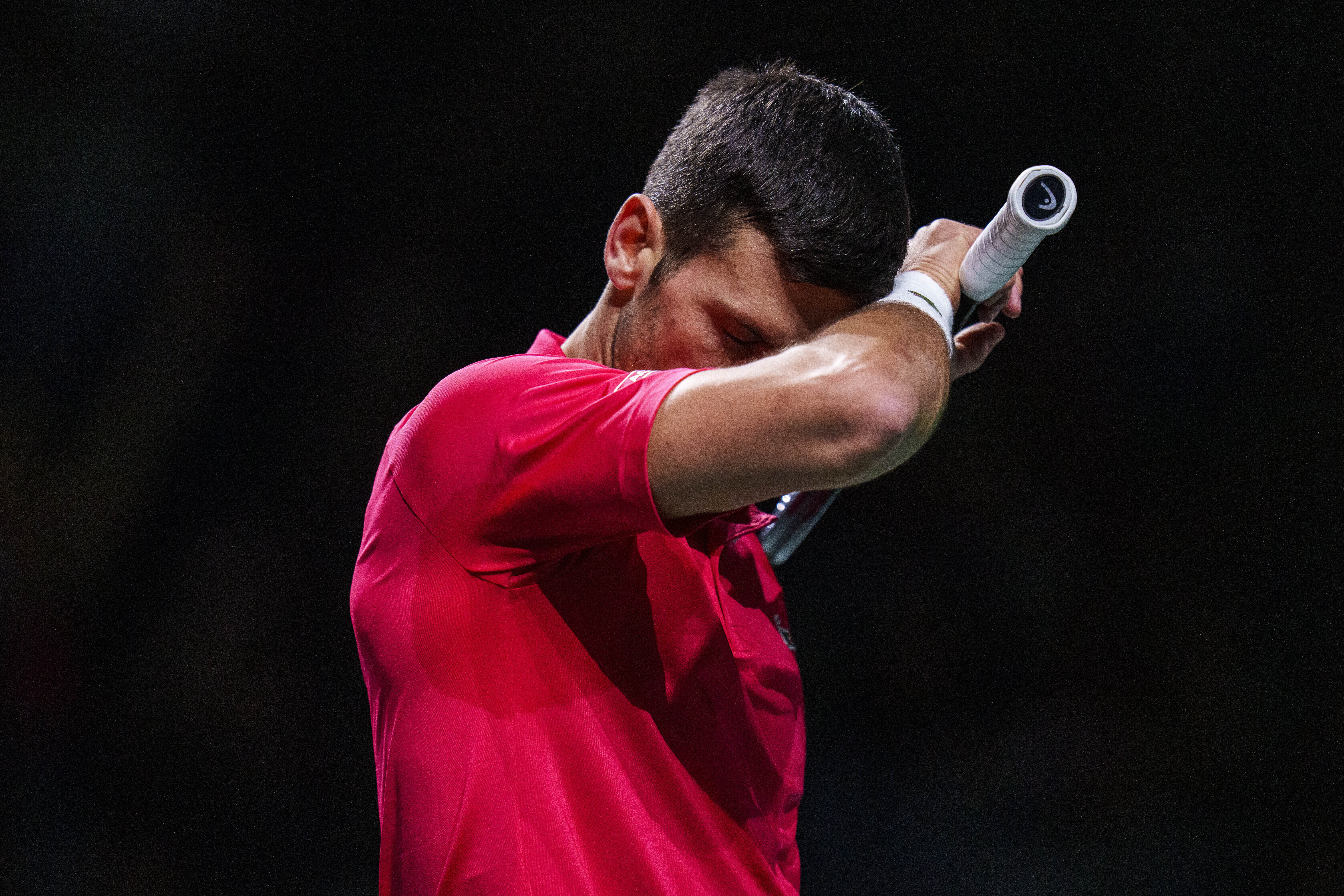 Novak Djokovic of Serbia reacts against Jannik Sinner of Italy during a Davis Cup semi-final tennis match between Italy and Serbia in Malaga, Spain, Saturday, Nov. 25, 2023. (AP Photo/Manu Fernandez)