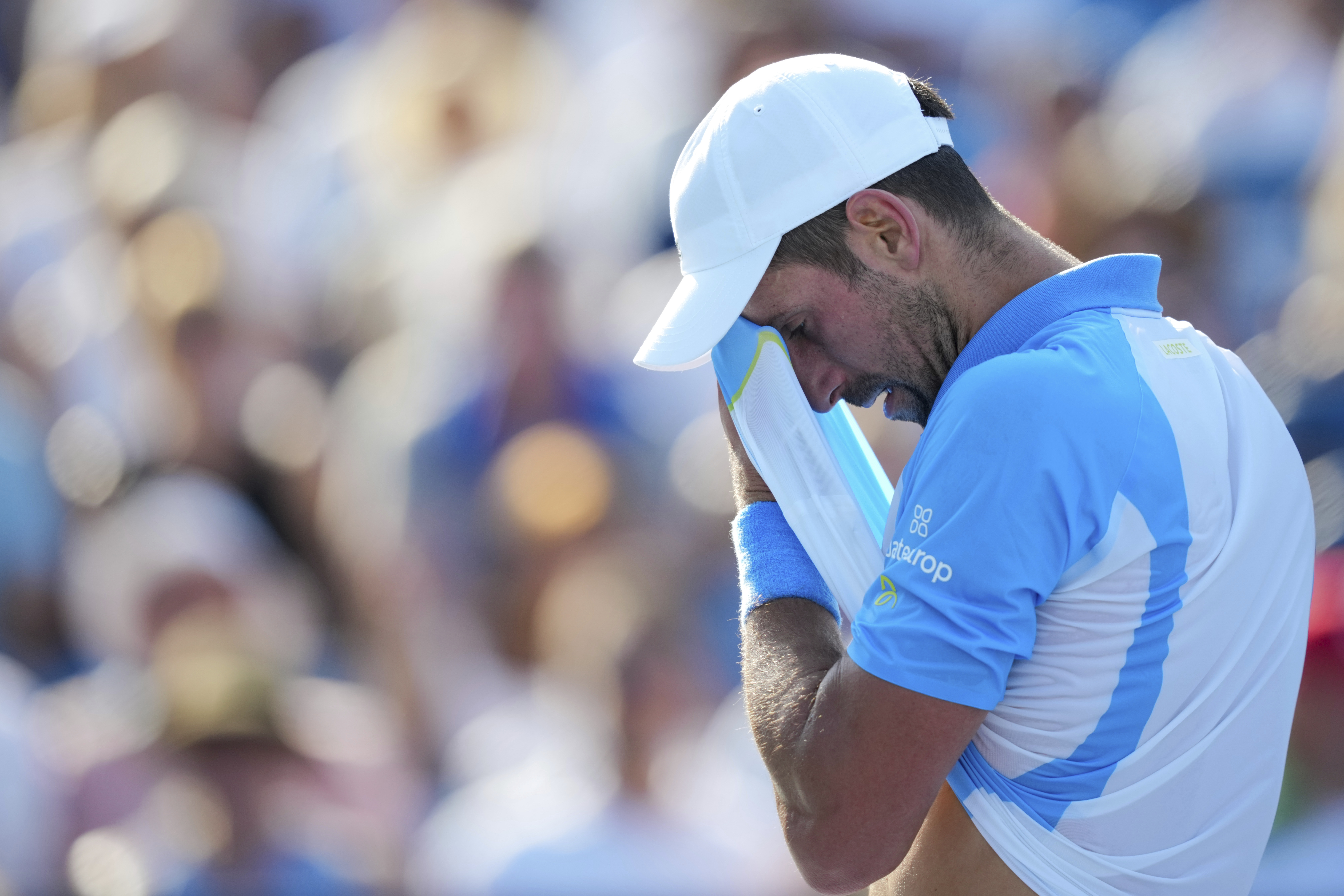 Novak Djokovic, of Serbia, wipes his face after returning a shot to Carlos Alcaraz, of Spain, during the men's singles final of the Western &amp; Southern Open tennis tournament, Sunday, Aug. 20, 2023, in Mason, Ohio. (AP Photo/Aaron Doster)