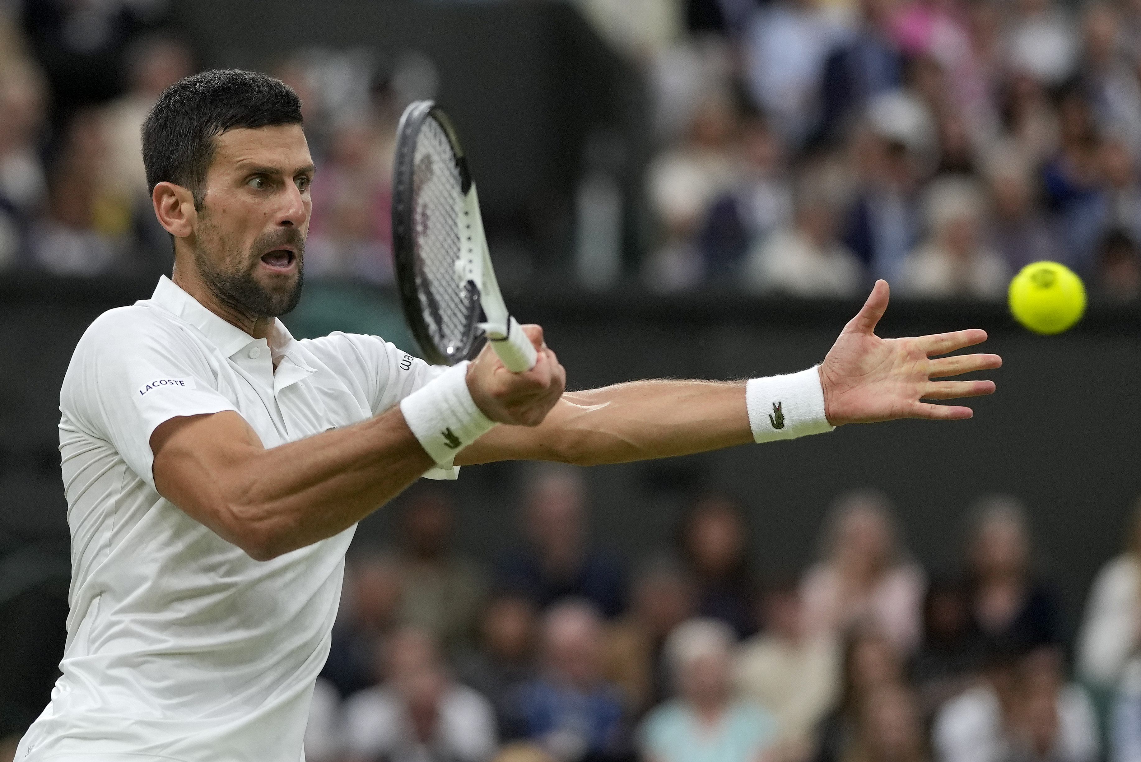 Serbia's Novak Djokovic returns to Italy's Jannik Sinner in a men's singles semifinal match on day twelve of the Wimbledon tennis championships in London, Friday, July 14, 2023. (AP Photo/Alastair Grant)
