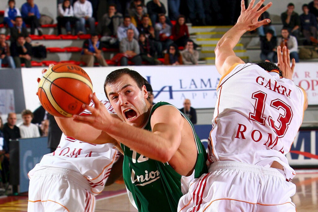 epa00889676 Marko Milic (C) of Union Olimpija Lubiana and Luca Garri (R) of Lottomatica Virtus Roma in action during their Euroleague Basketball match in Rome, Italy, on Wednesday 20 December 2006.  EPA/CASTORIA