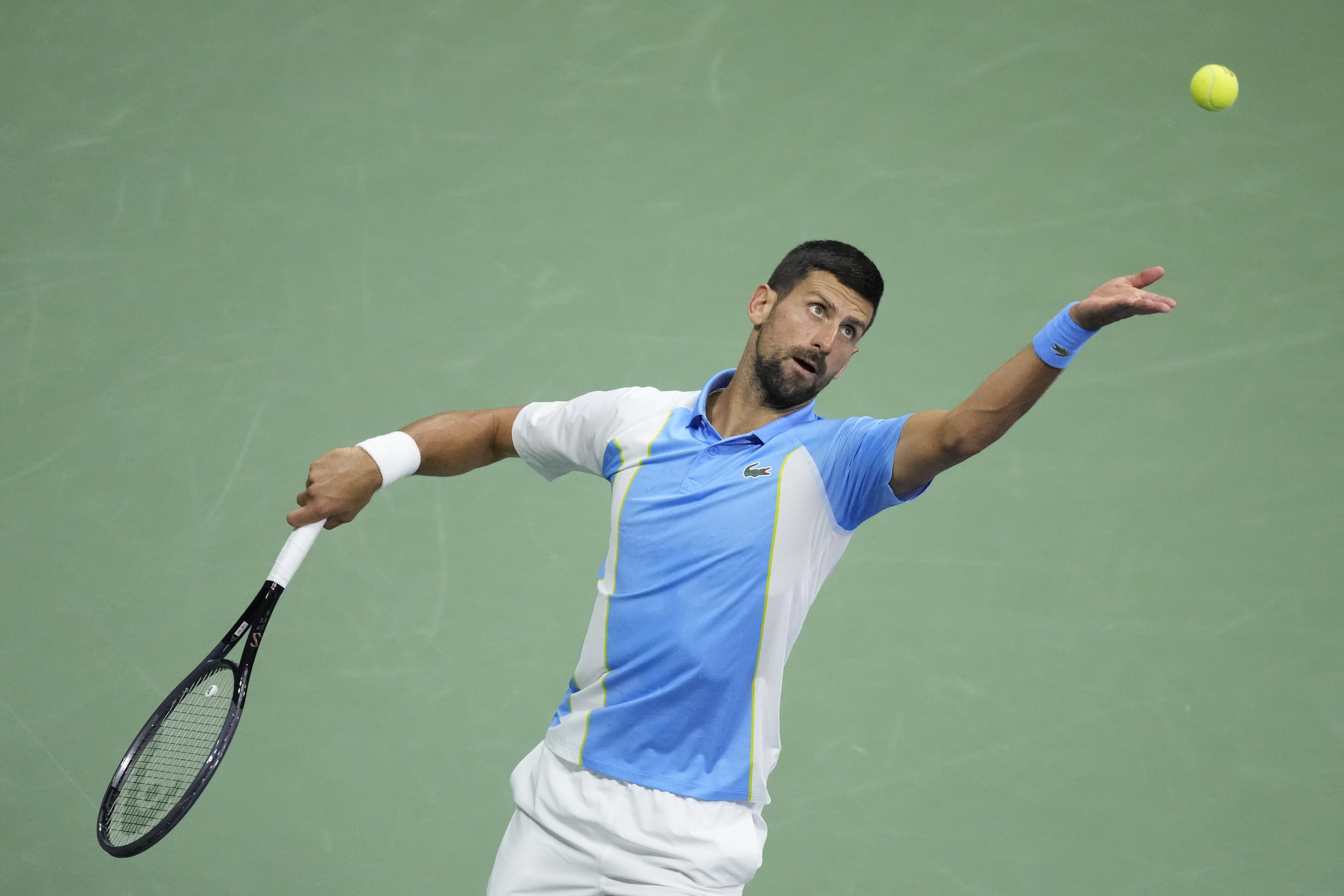 Novak Djokovic, of Serbia, serves to Ben Shelton, of the United States, during the men's singles semifinals of the U.S. Open tennis championships, Friday, Sept. 8, 2023, in New York. (AP Photo/John Minchillo)