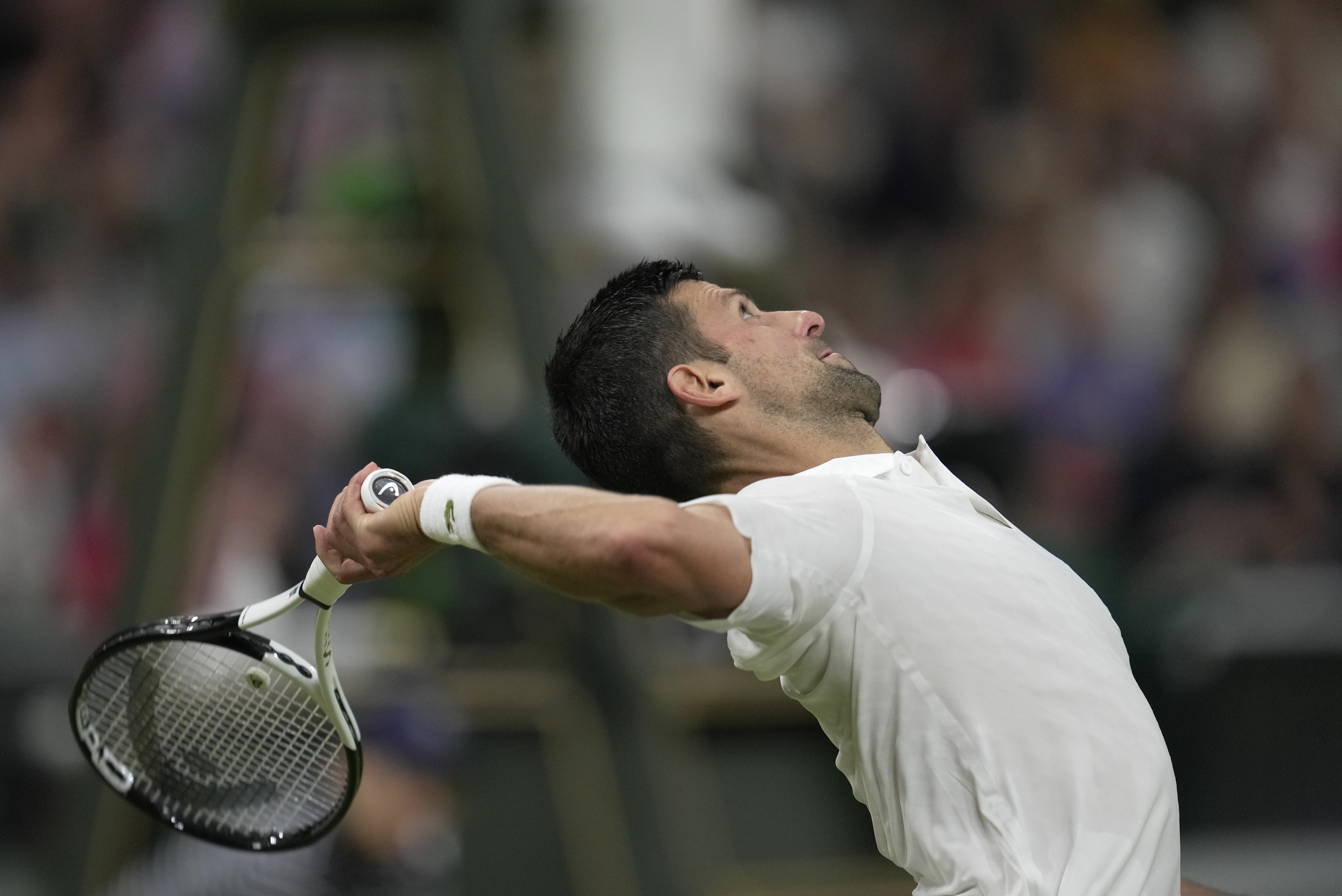Serbia's Novak Djokovic serves to Switzerland's Stan Wawrinka in a men's singles match on day five of the Wimbledon tennis championships in London, Friday, July 7, 2023. (AP Photo/Kin Cheung)