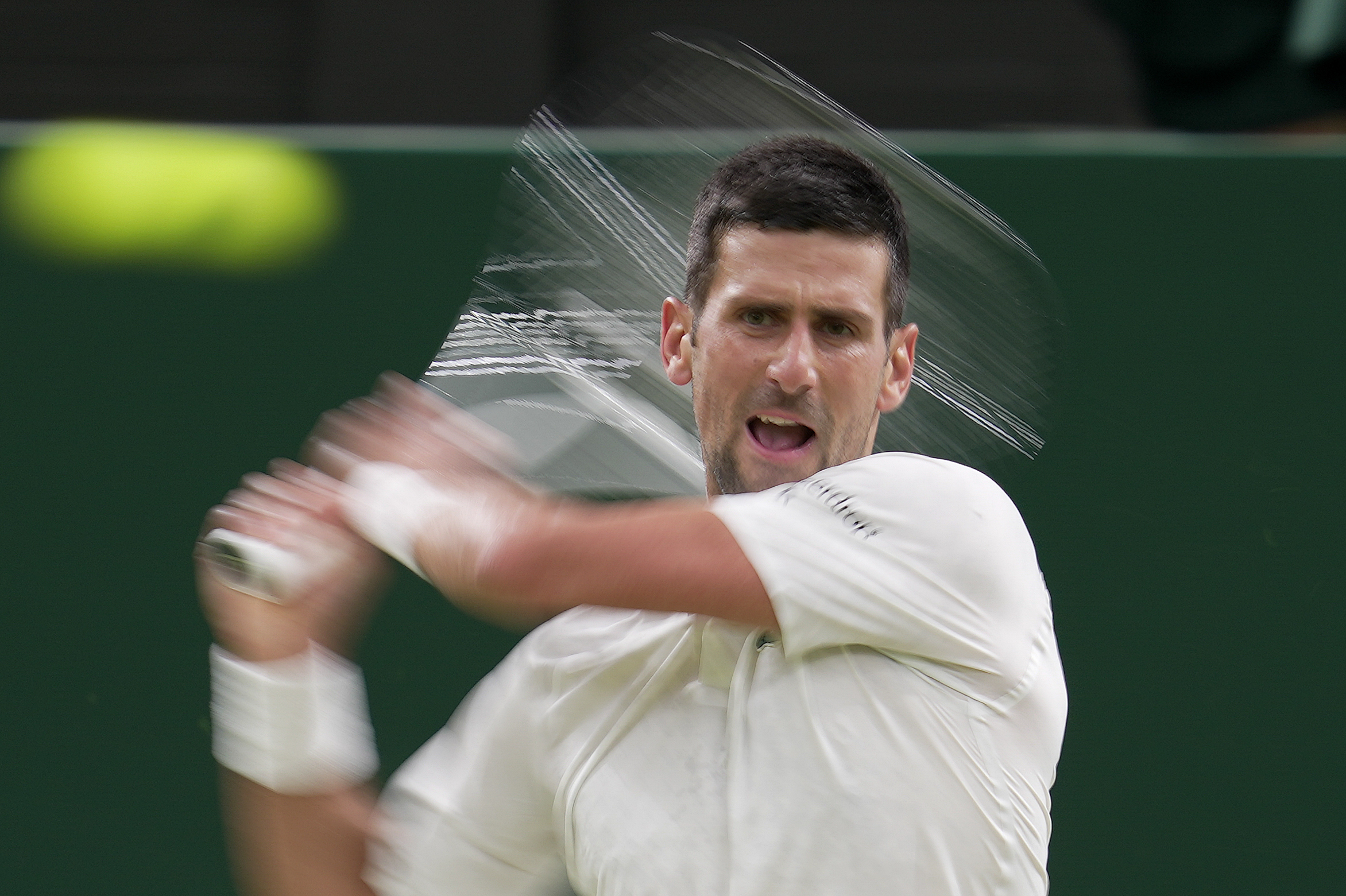Serbia's Novak Djokovic returns to Switzerland's Stan Wawrinka in a men's singles match on day five of the Wimbledon tennis championships in London, Friday, July 7, 2023. (AP Photo/Kin Cheung)
