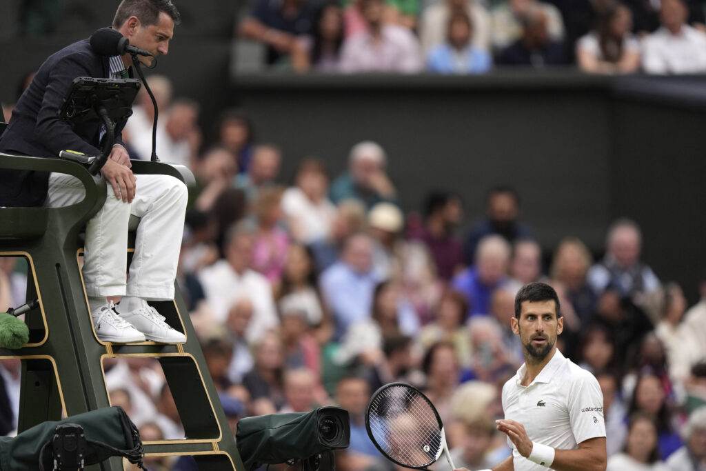 Serbia's Novak Djokovic remonstrates with umpire Richard Haigh during his men's singles semifinal match against Italy's Jannik Sinner on day twelve of the Wimbledon tennis championships in London, Friday, July 14, 2023. (AP Photo/Alberto Pezzali)