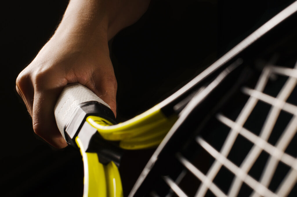 Hand on grip and swinging a tennis racket. Isolated on black background. tenis vimbldon