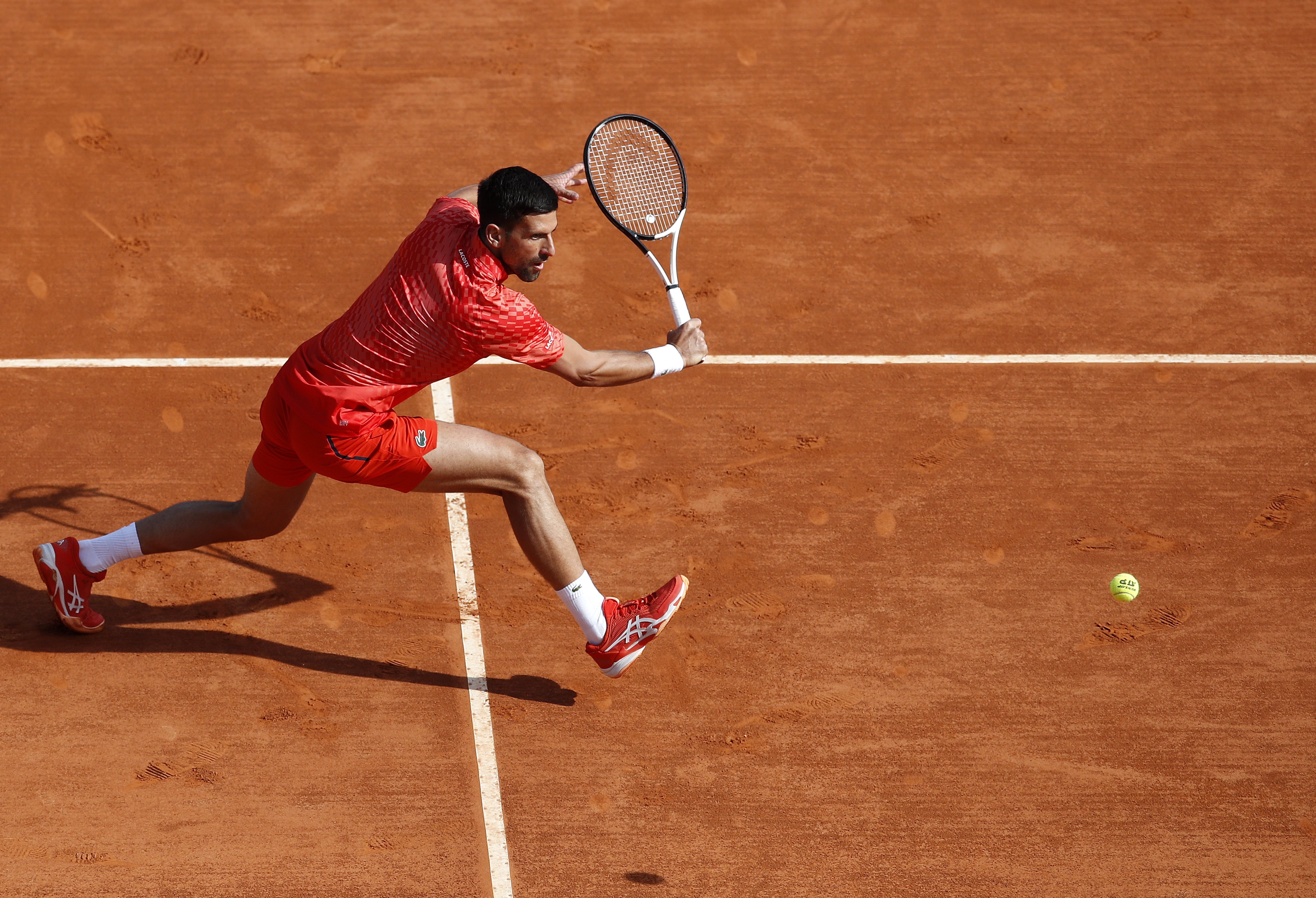 epa10568447 Novak Djokovic of Serbia returns the ball to Ivan Gakhov during their first round match at the Monte-Carlo Rolex Masters tournament in Roquebrune Cap Martin, France, 11 April 2023.  EPA-EFE/SEBASTIEN NOGIER