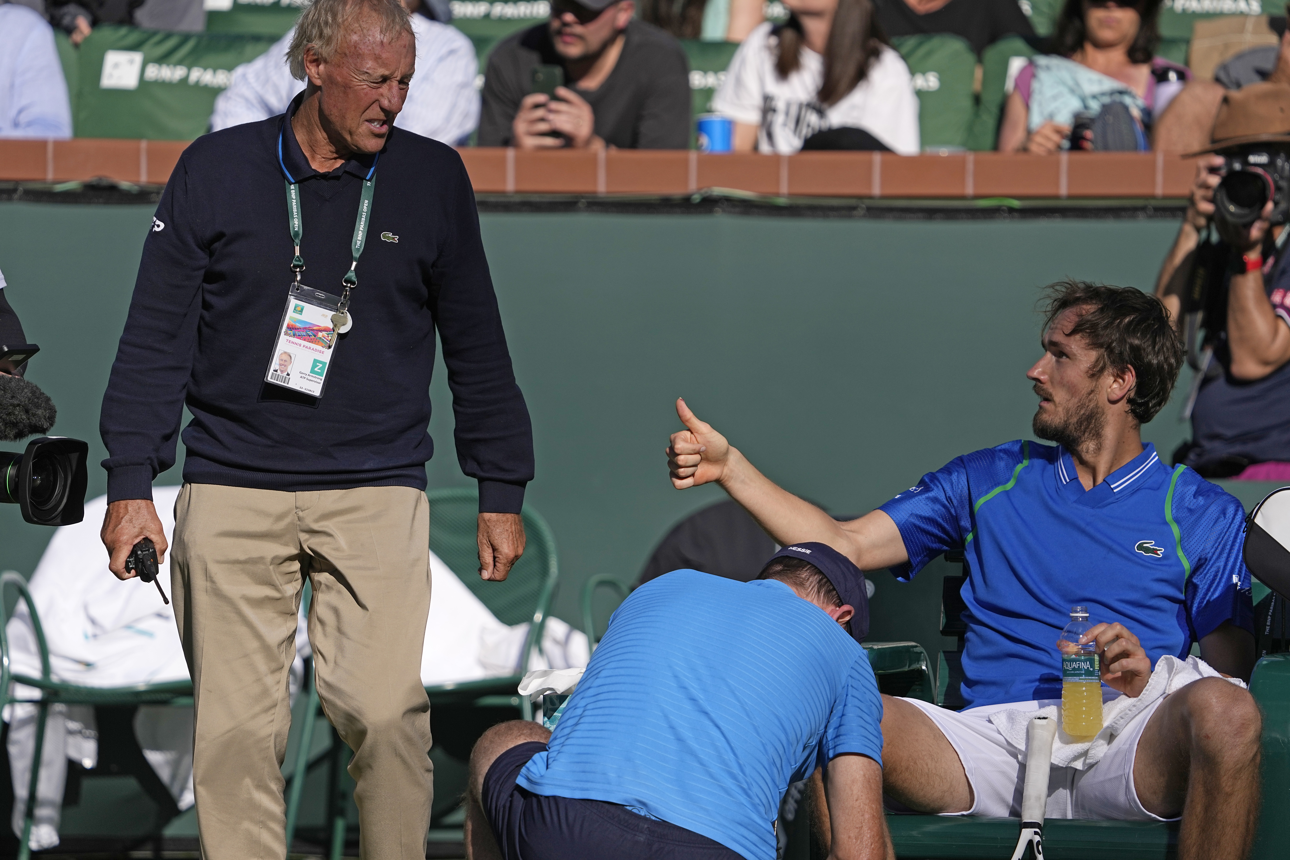 An official looks at Daniil Medvedev, of Russia, cut thumb during his match against Alejandro Davidovich Fokina, of Spain, at the BNP Paribas Open tennis tournament Wednesday, March 15, 2023, in Indian Wells, Calif. (AP Photo/Mark J. Terrill)