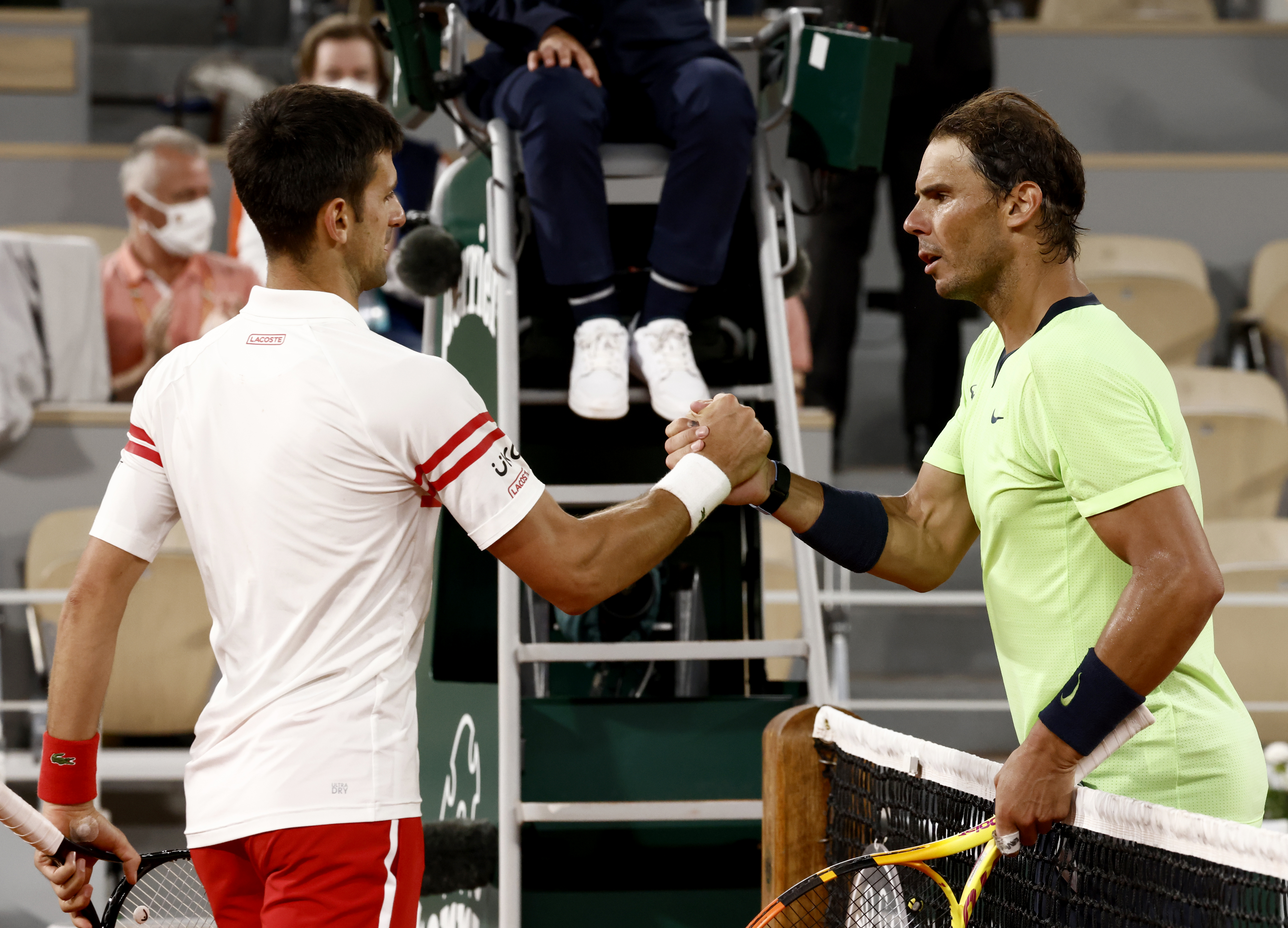 epa09263602 Novak Djokovic (L) of Serbia shakes hands with Rafael Nadal (R) of Spain after their semi final match at the French Open tennis tournament at Roland Garros in Paris, France, 11 June 2021. Djokovic won in four sets.  EPA-EFE/YOAN VALAT