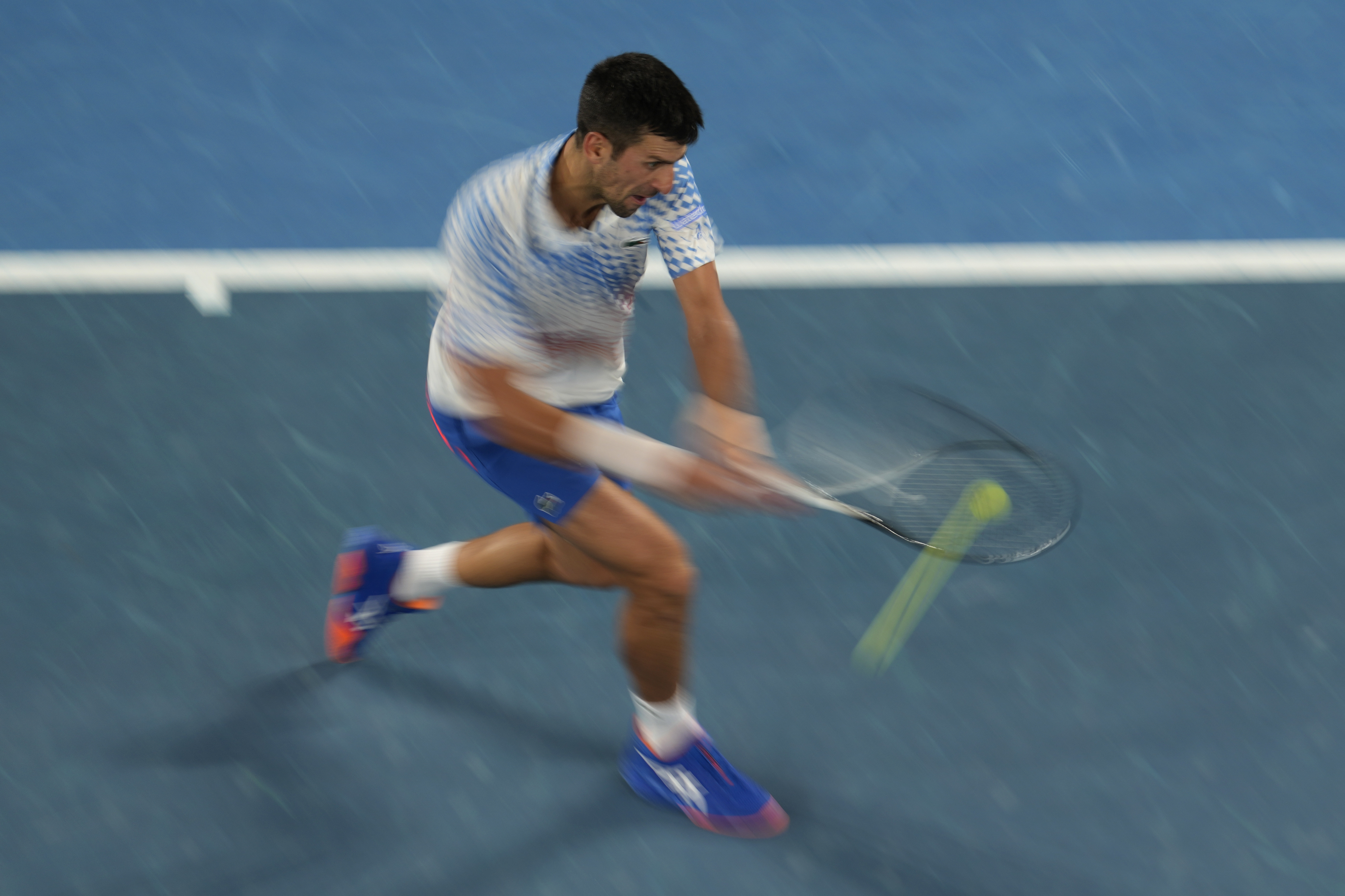 Novak Djokovic of Serbia plays a backhand return to Stefanos Tsitsipas of Greece during the men's singles final at the Australian Open tennis championships in Melbourne, Australia, Sunday, Jan. 29, 2023. (AP Photo/Ng Han Guan)