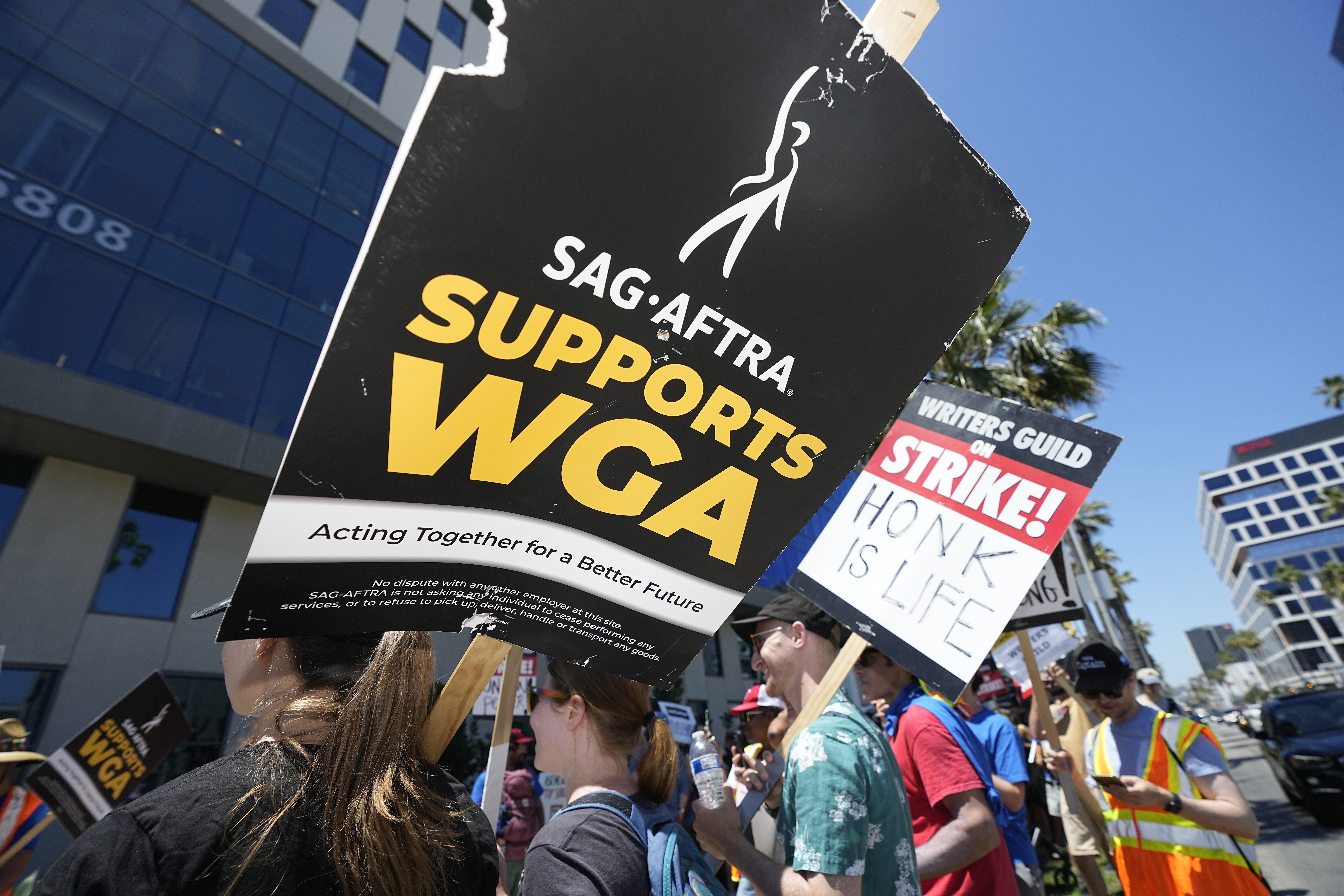 Picketers carry signs outside Netflix during a Writers Guild rally on Thursday, July 13, 2023, in Los Angeles. (AP Photo/Mark J. Terrill)