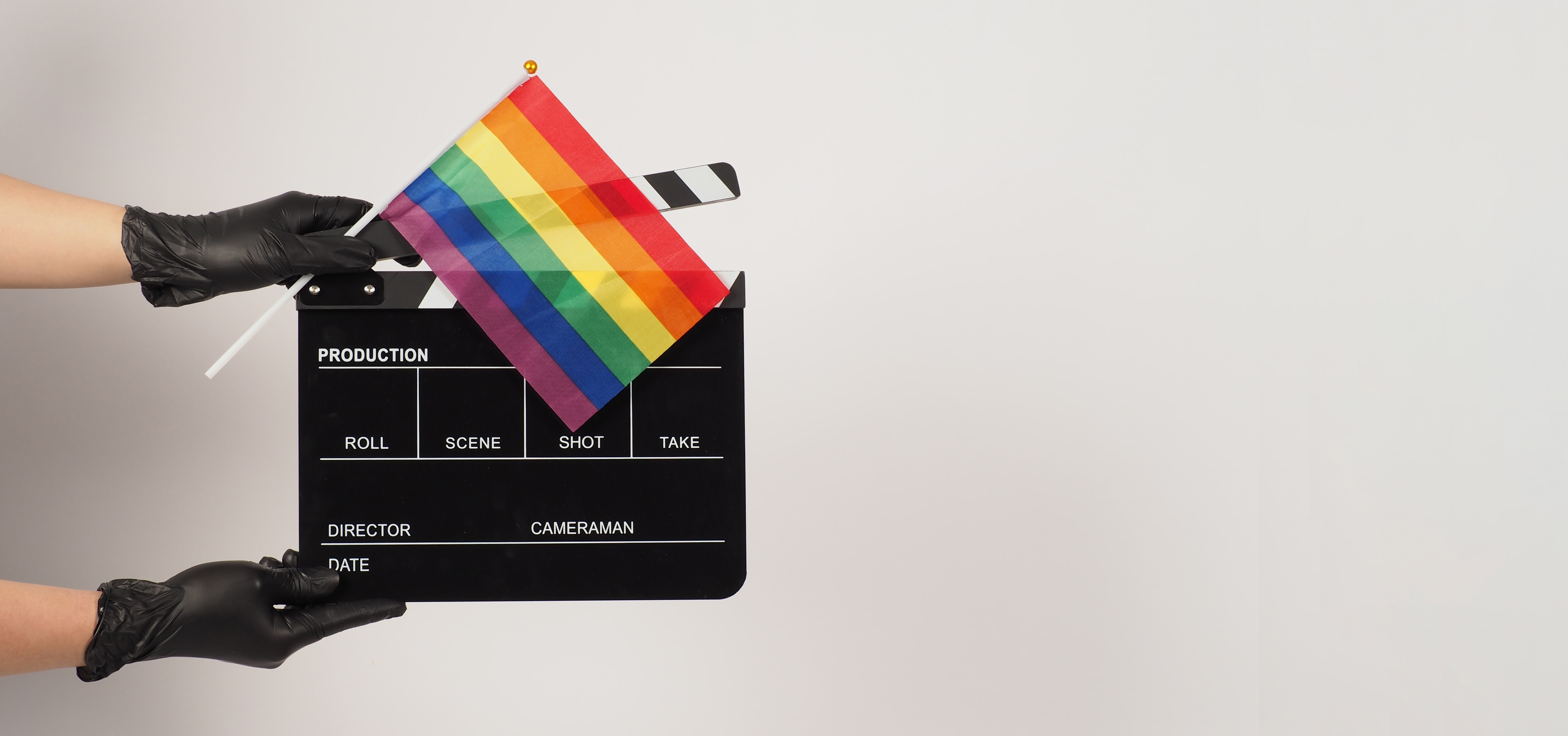 Hands is hold movie slate or clapper board and rainbow flag. Hands is wear black latex gloves
film, lgbt russia