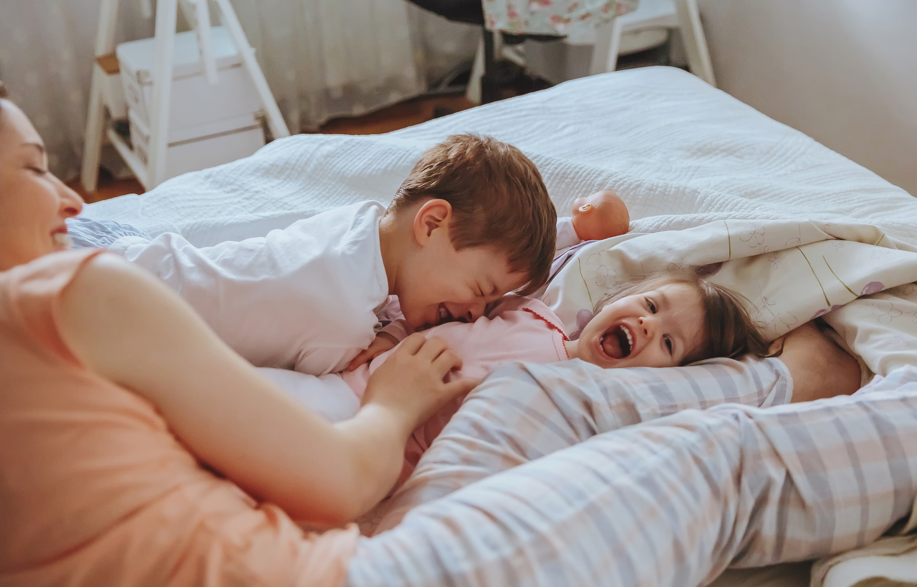 Closeup,Of,Happy,Family,Playing,Over,The,Bed,In,A