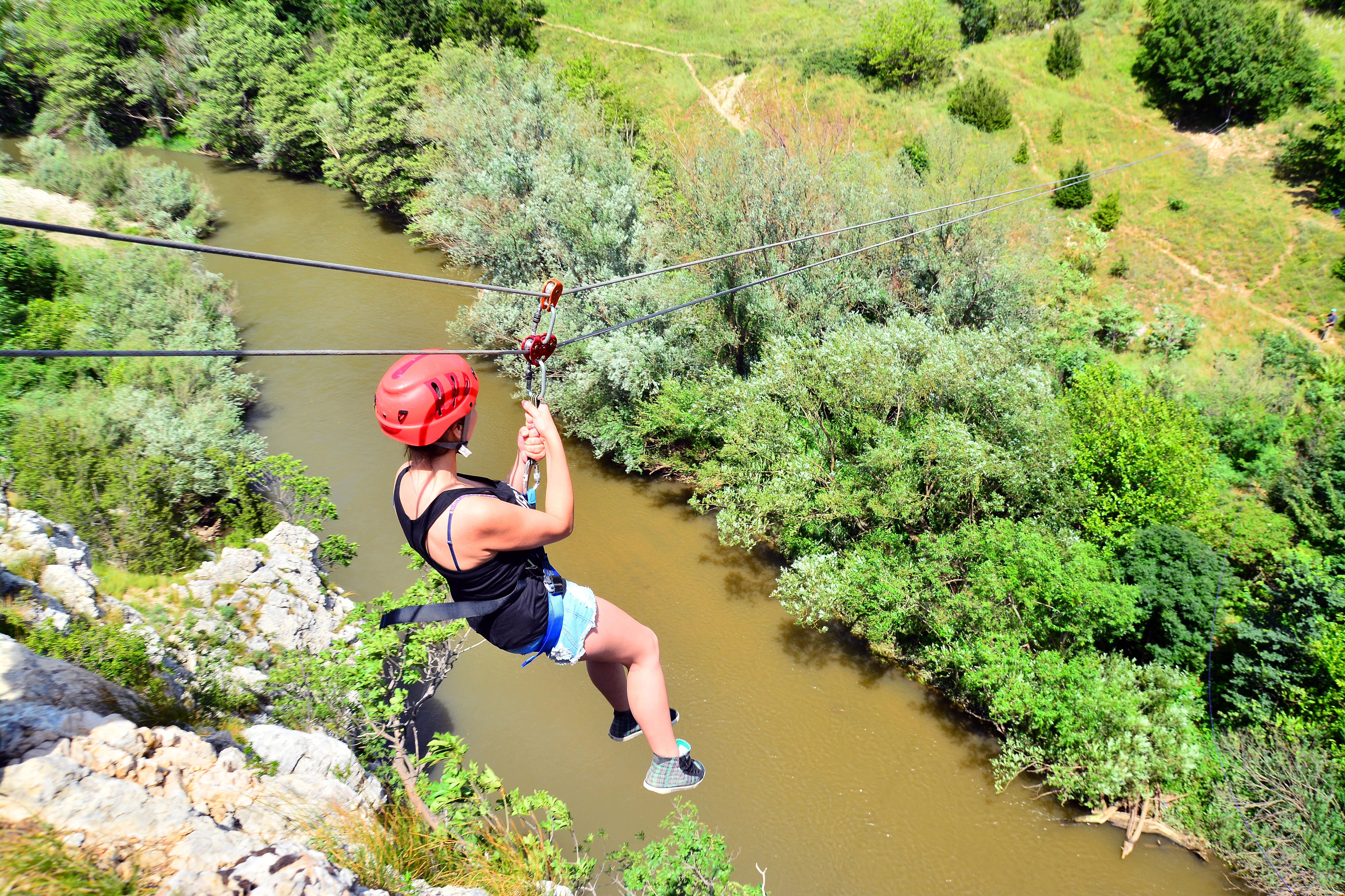 Young,Woman,Descending,On,A,Zip-line,(flying,Fox)