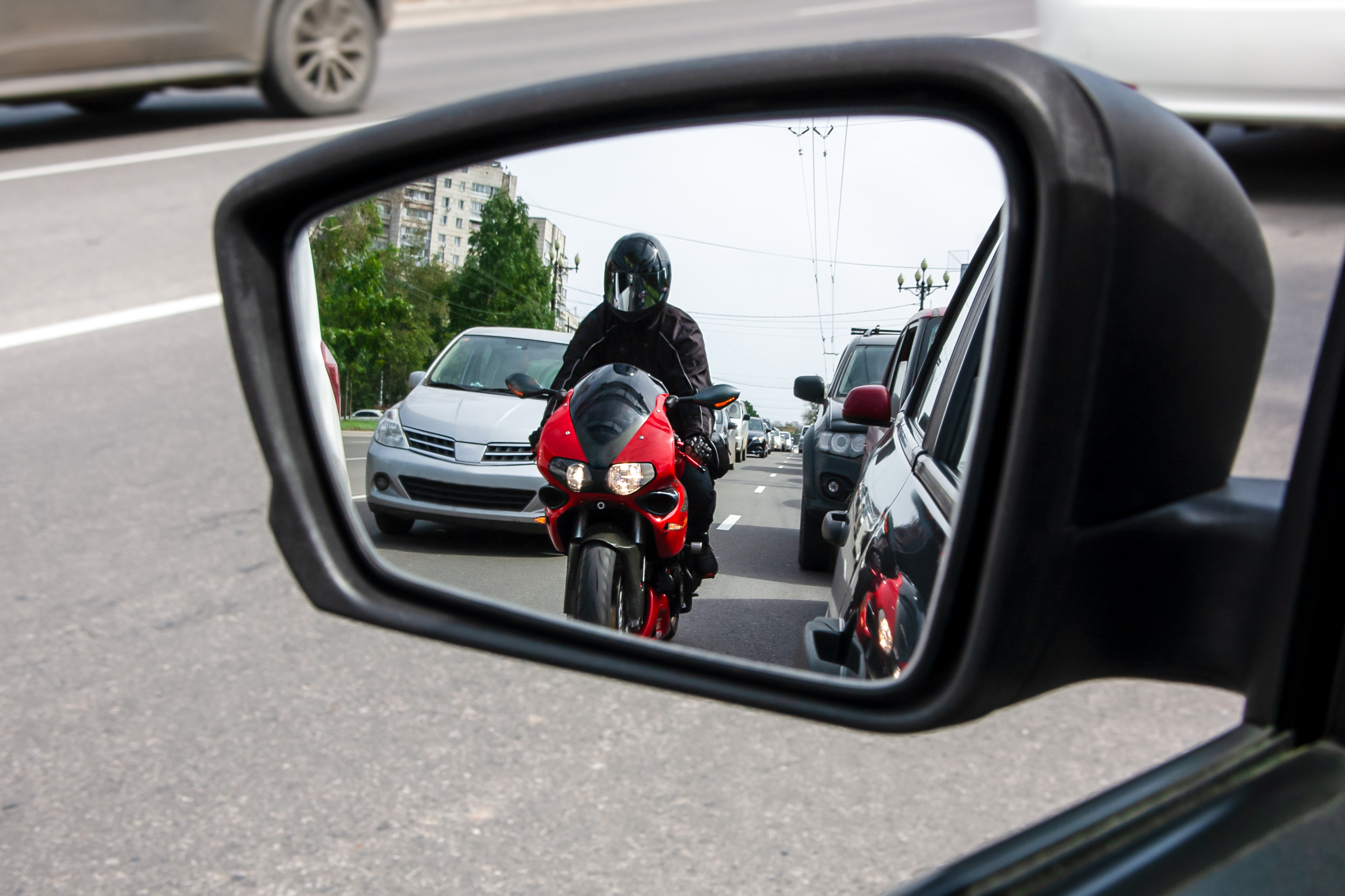 The,Side,Mirror,Of,The,Car,Reflects,A,Motorcyclist,Who