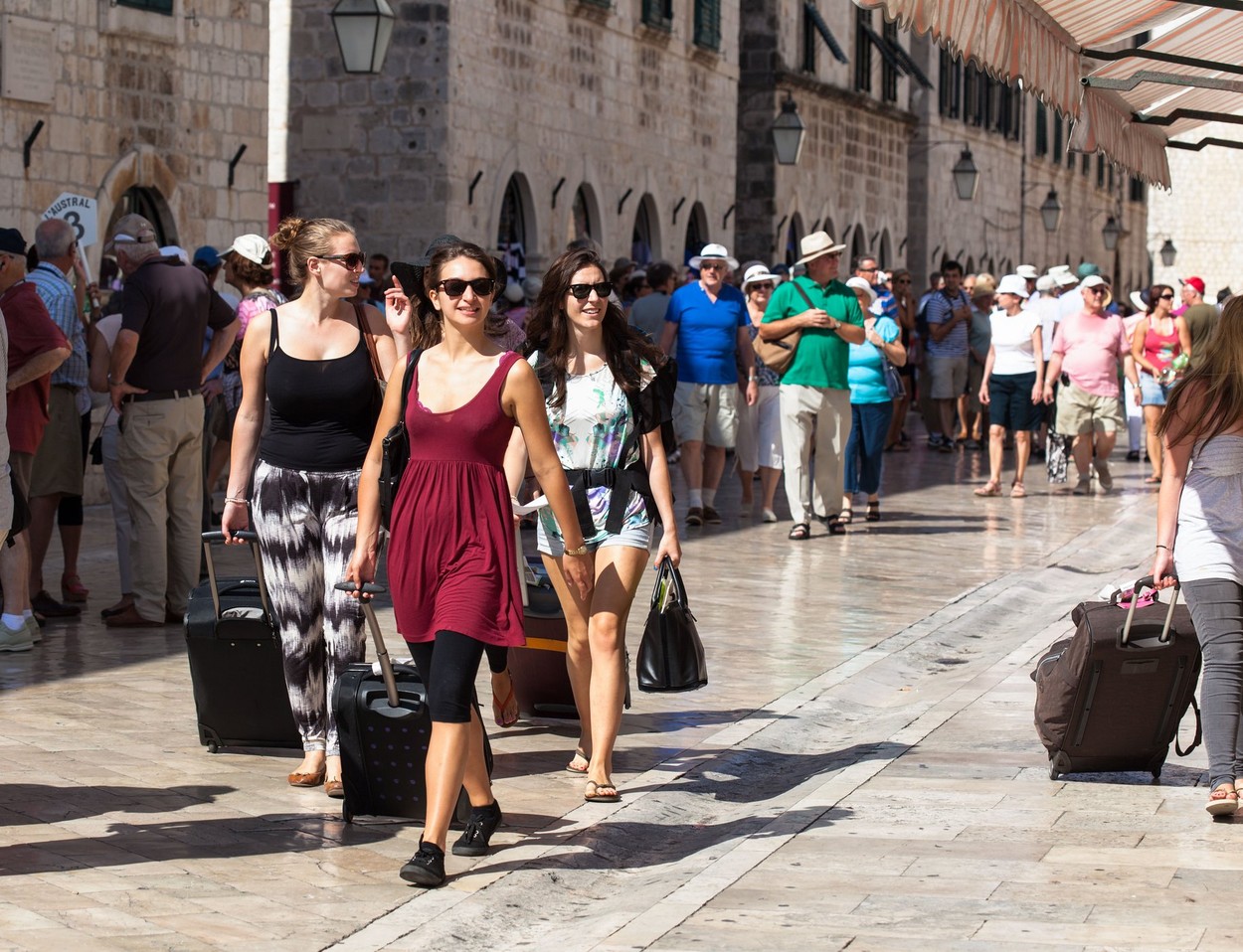 Girl tourists walking with suitcases down the main street (Placa) Dubrovnik Croatia