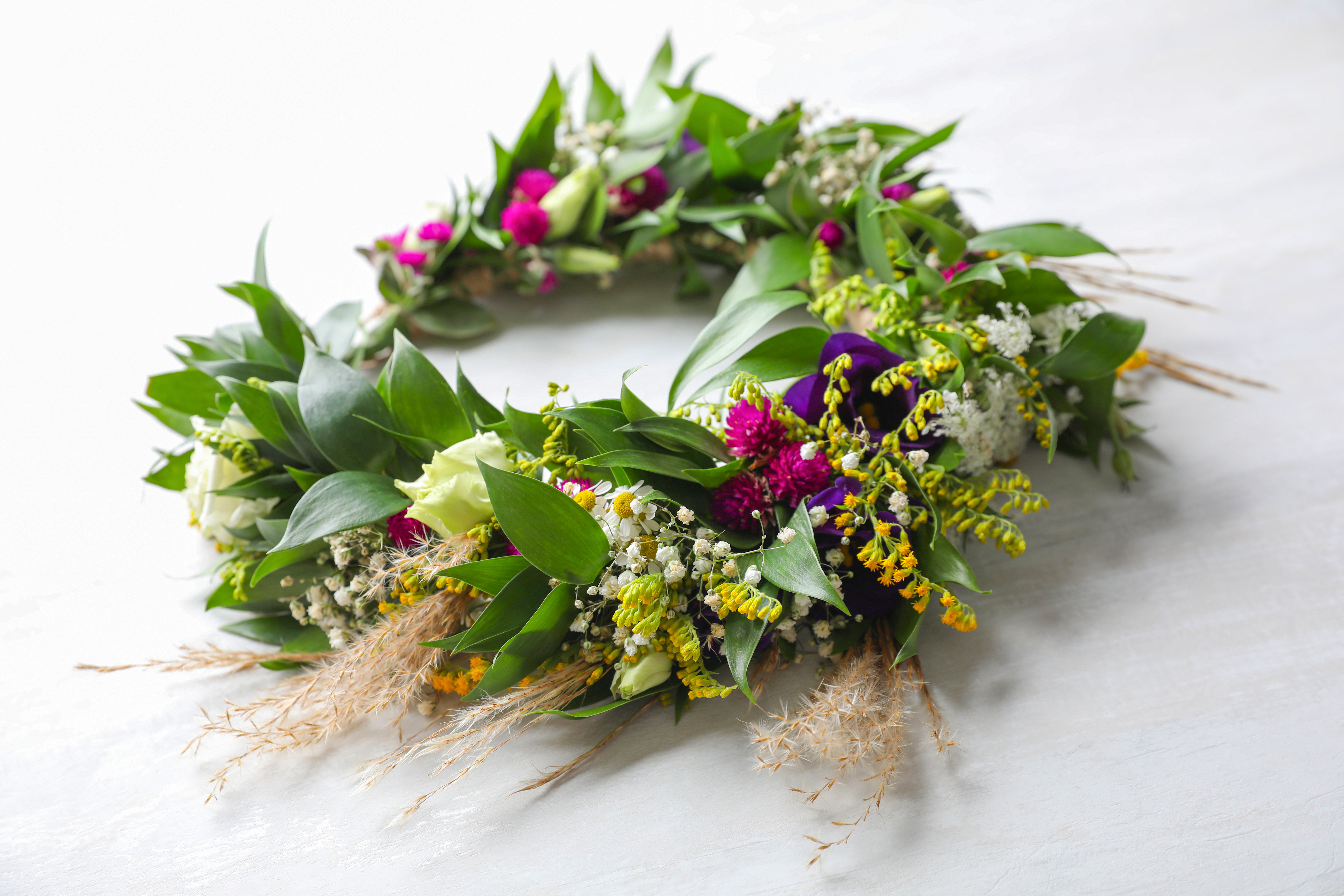 Beautiful,Wreath,Made,Of,Flowers,And,Leaves,On,White,Table