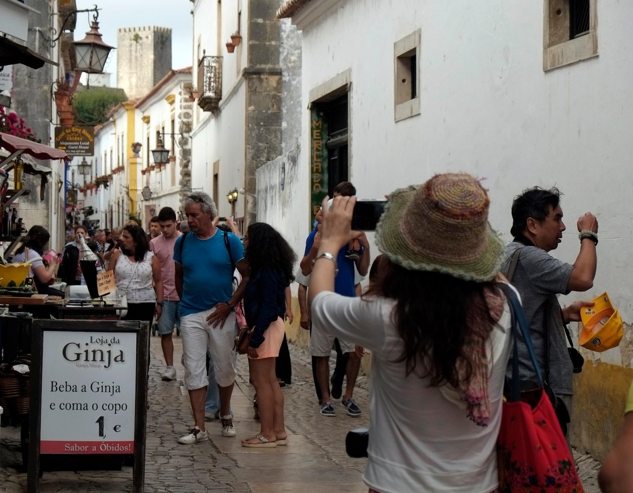 Tourists take photographs in one of the narrow streets in Obidos, Portugal August 23, 2017. © John Voos