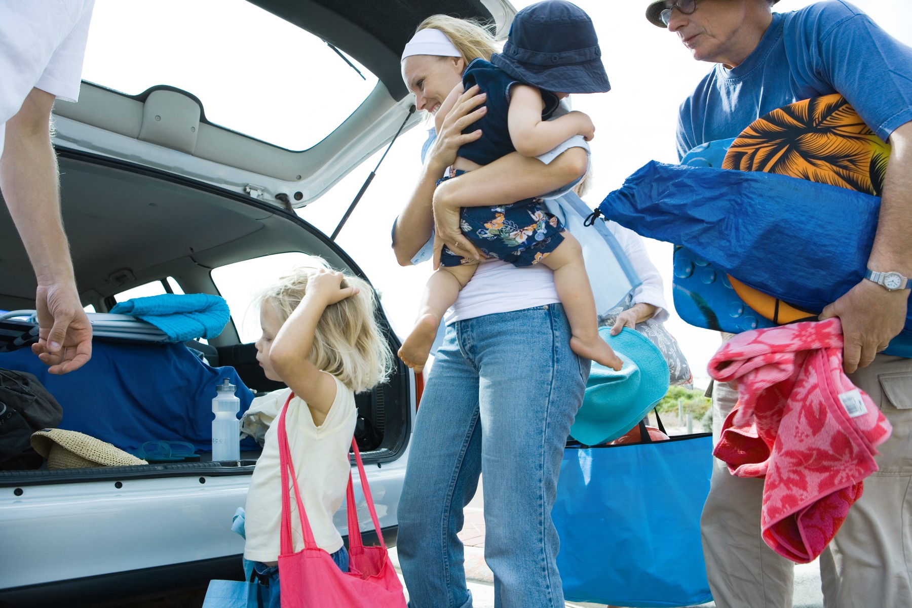 Family unloading trunk of car