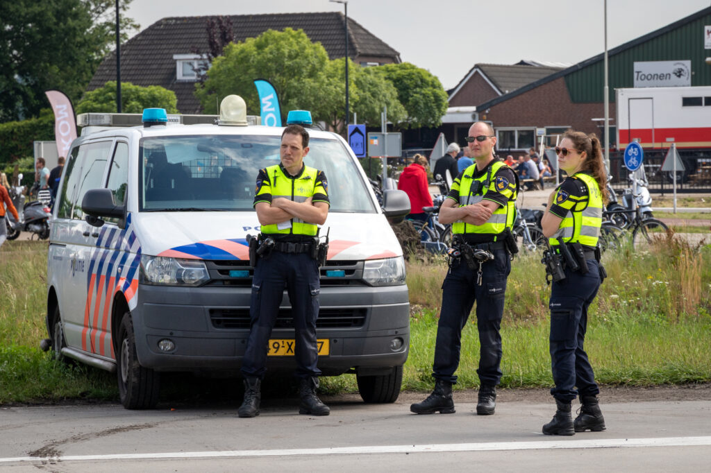 VOLKEL, NETHERLANDS - JUN 15, 2019: Dutch police men and woman on watch near their police car during the Dutch Air Force Days.