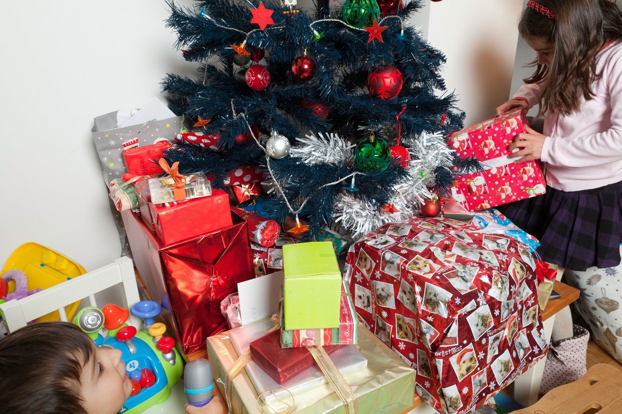 Children opening present under the Christmas tree