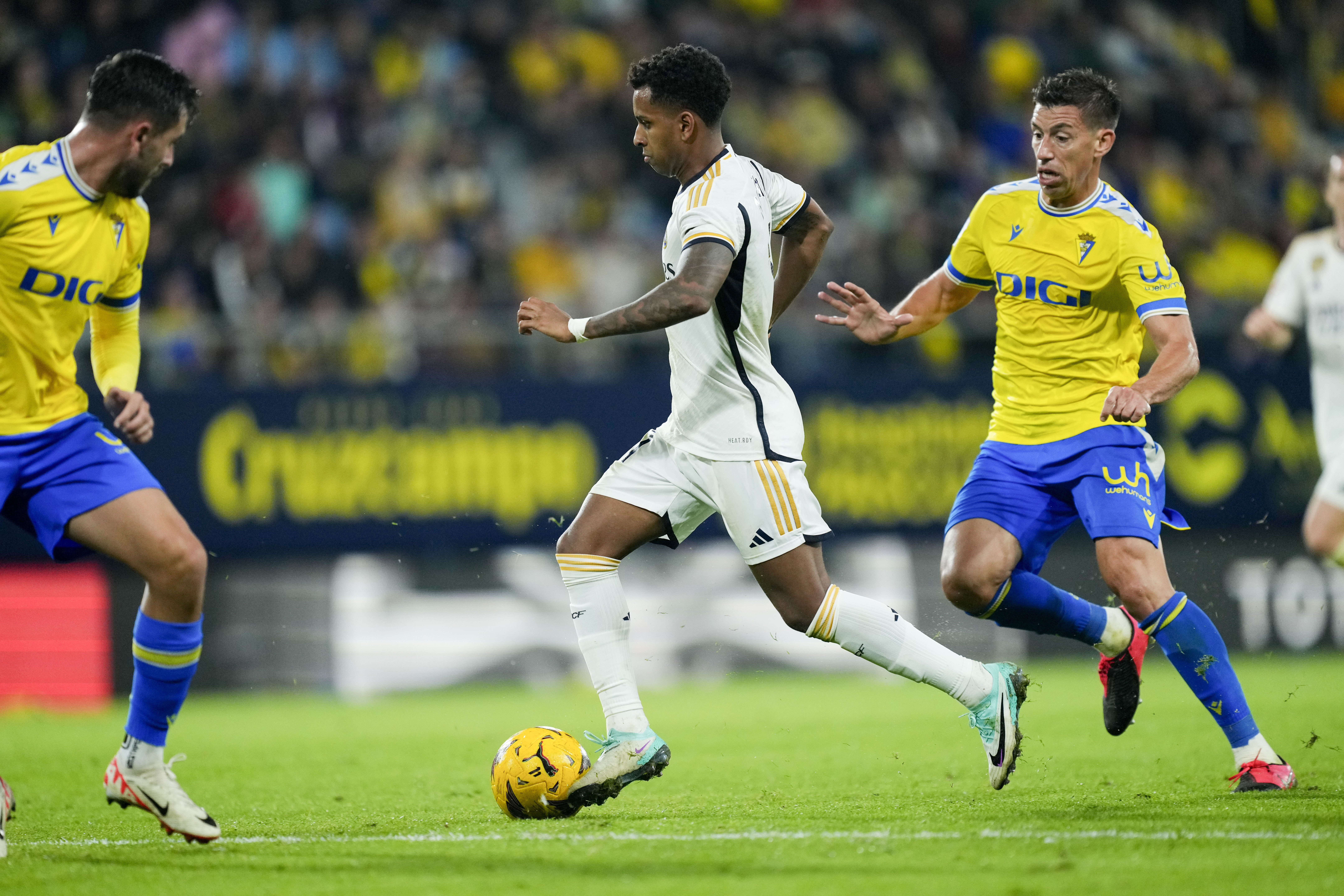 Real Madrid's Rodrygo, center, dribbles the ball in front of Cadiz's Ruben Alcaraz, left, during Spanish La Liga soccer match between Cadiz FC and Real Madrid at the Nuevo Mirandilla stadium in Cadiz, Spain, Sunday, Nov. 26, 2023. (AP Photo/Jose Breton)