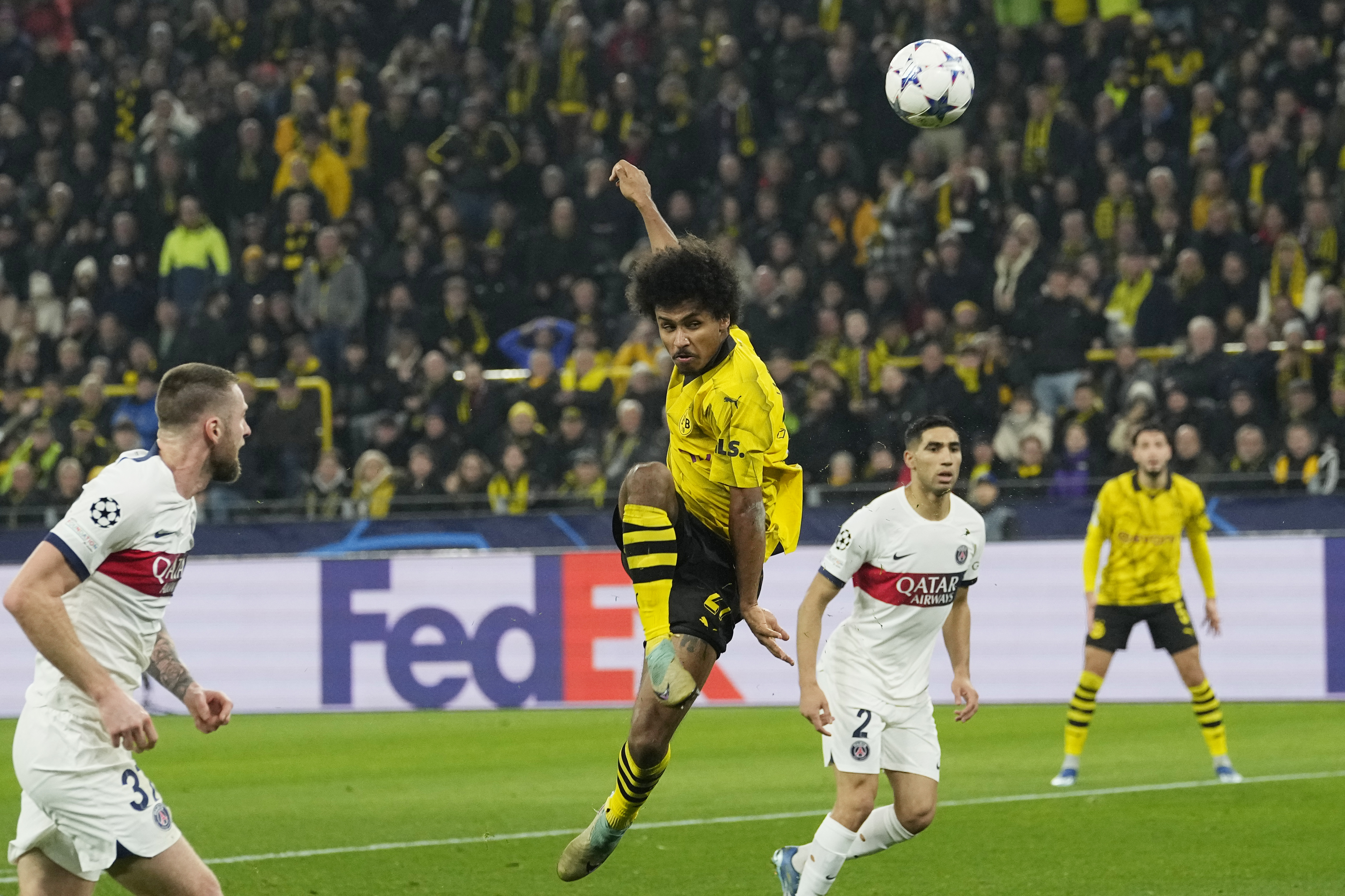 Dortmund's Karim Adeyemi, centre, shoots the ball during the Champions League Group F soccer match between Borussia Dortmund and Paris Saint-Germain at the Signal Iduna Park in Dortmund, Germany, Wednesday, Dec. 13, 2023. (AP Photo/Martin Meissner)