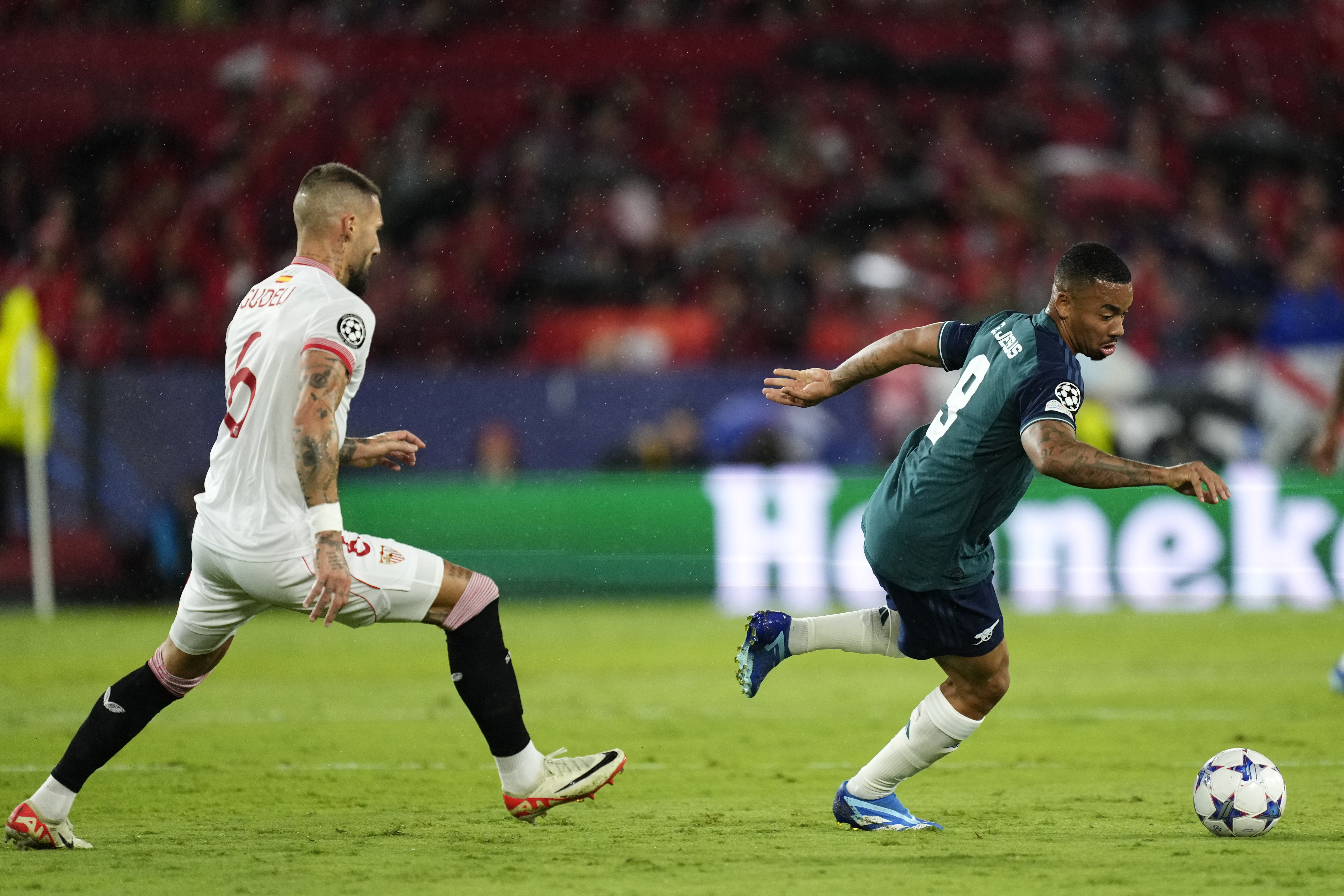 Sevilla's Nemanja Gudelj, left, challenges Arsenal's Gabriel Jesus during the Champions League Group B soccer match between Sevilla and Arsenal at the Ramon Sanchez-Pizjuan stadium in Seville, Spain, Tuesday Oct. 24, 2023. (AP Photo/Jose Breton)