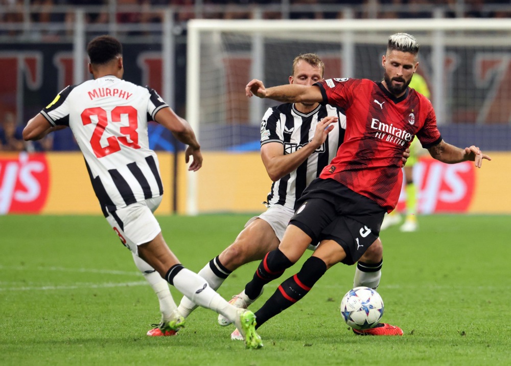 epa10870078 AC Milan's Olivier Giroud (R) in actionagainst Newcastle's Dan Burn (C) during the UEFA Champions League group F soccer match between AC Milan and Newcastle United, in Milan, Italy, 19 September 2023.  EPA-EFE/MATTEO BAZZI
