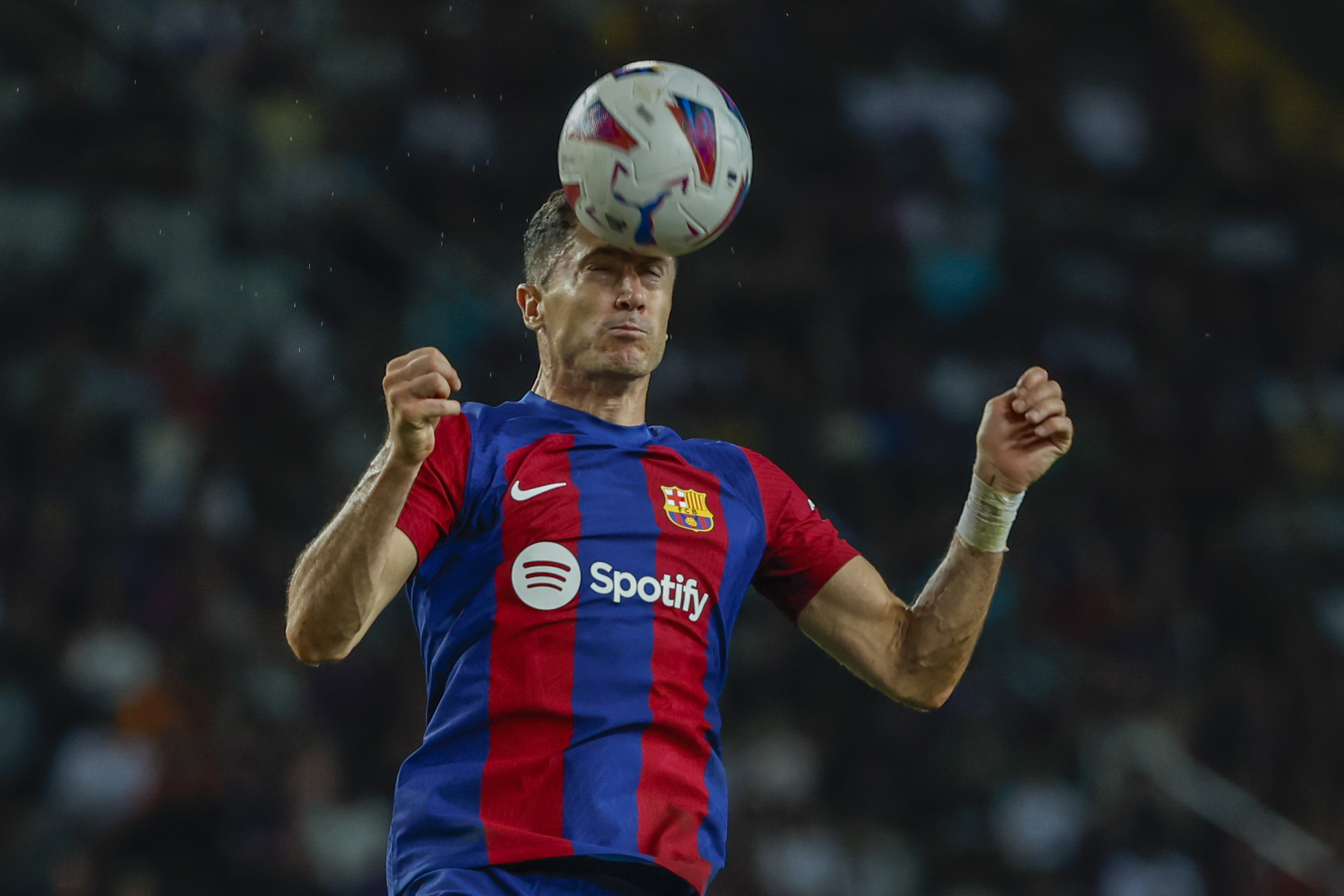 Barcelona's Robert Lewandowski heads the ball during a Spanish La Liga soccer match between Barcelona and Sevilla, at the Olympic Stadium of Montjuic in Barcelona, Spain, Friday, Sept. 29, 2023. (AP Photo/Joan Monfort)