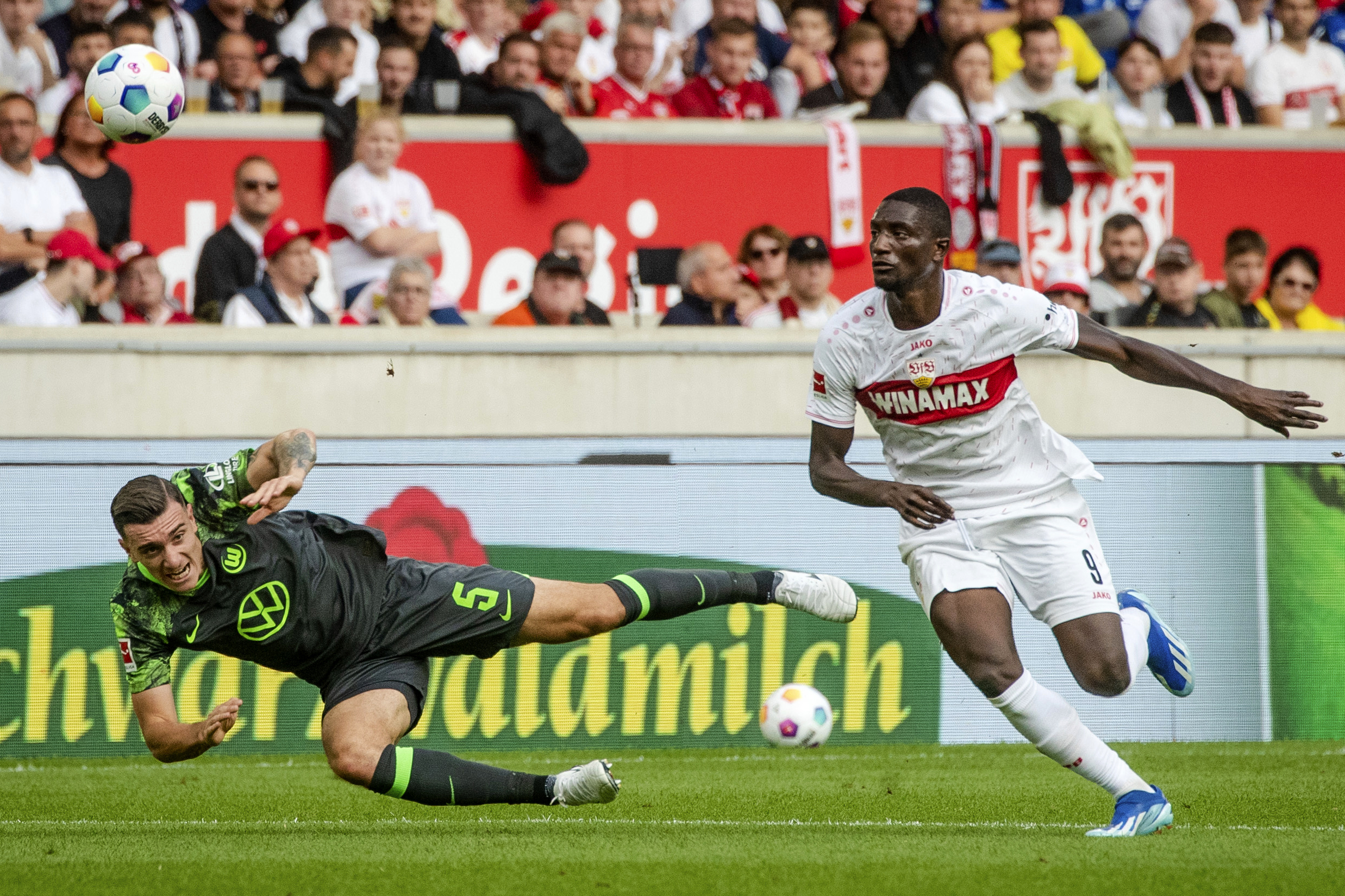VfB Stuttgart's Serhou Guirassy, right, vies for the ball with Wolfsburg's Cedric Zesiger during a Bundesliga soccer match between VfB Stuttgart and Wolfsburg, in Stuttgart's MHPArena, Germany, Saturday, Oct. 7, 2023. (Christoph Schmidt/dpa via AP)