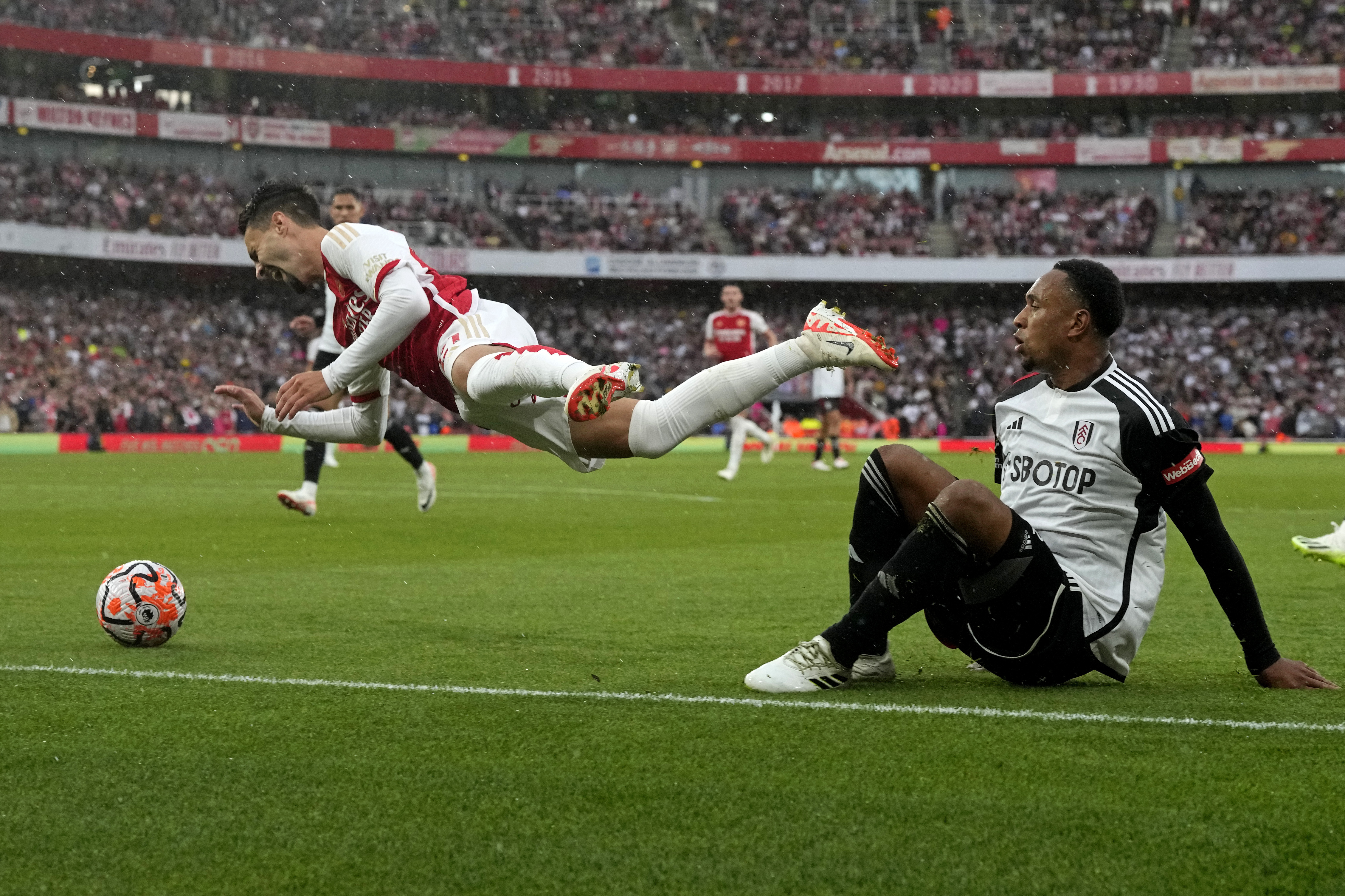 Arsenal's Fabio Vieira, left, is fouled by Fulham's Kenny Tete, right, during the English Premier League soccer match between Arsenal and Fulham at Emirates stadium in London, Saturday, Aug. 26, 2023. (AP Photo/Frank Augstein)