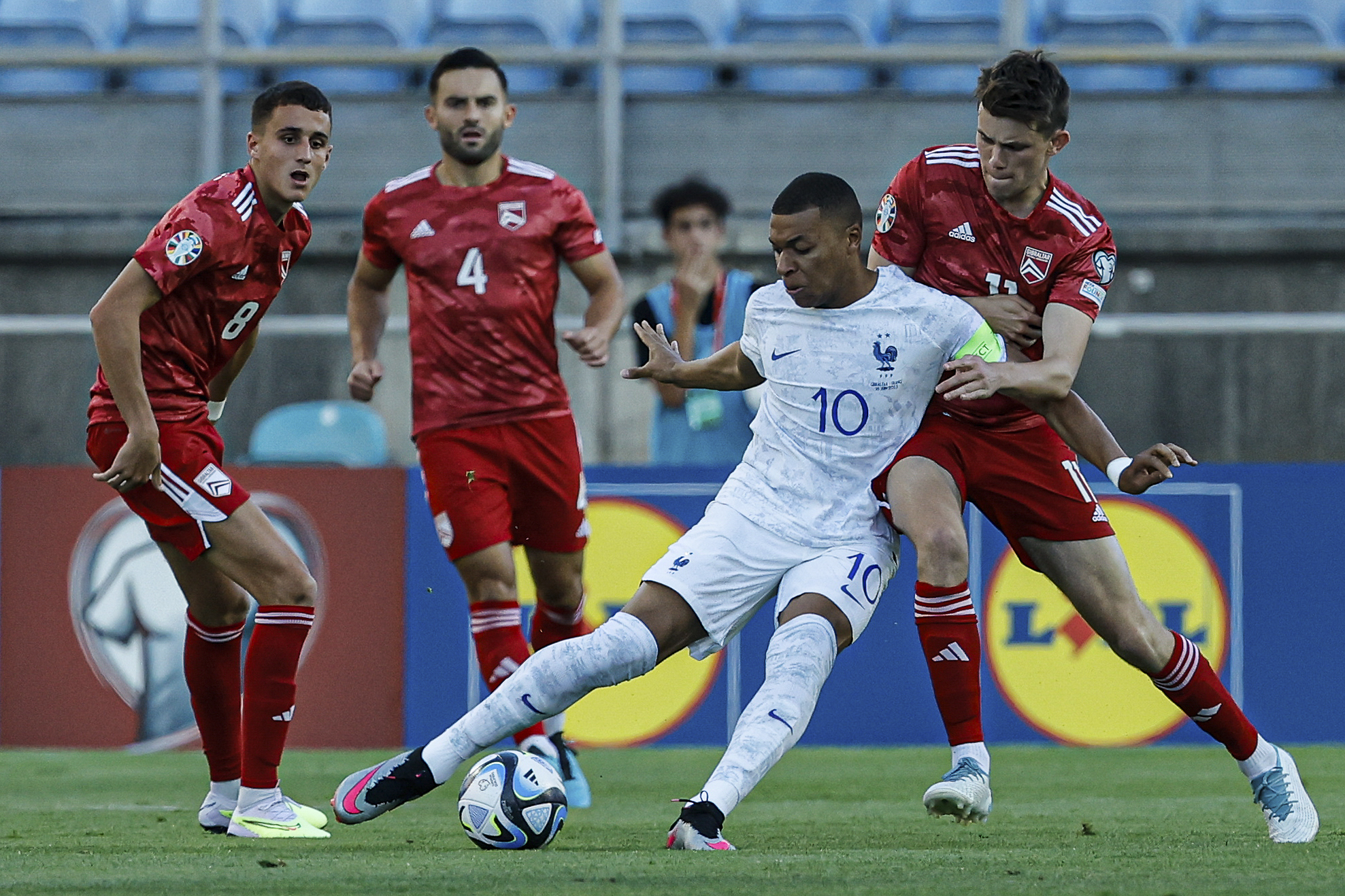 epa10695860 Gilbraltar player Julian Valarino (R) in action against France player Kylian Mbappe (2-R) during the UEFA Euro 2024 qualifying soccer match between Gibraltar and France in Faro, Portugal, 16 June 2023.  EPA-EFE/LUIS FORRA