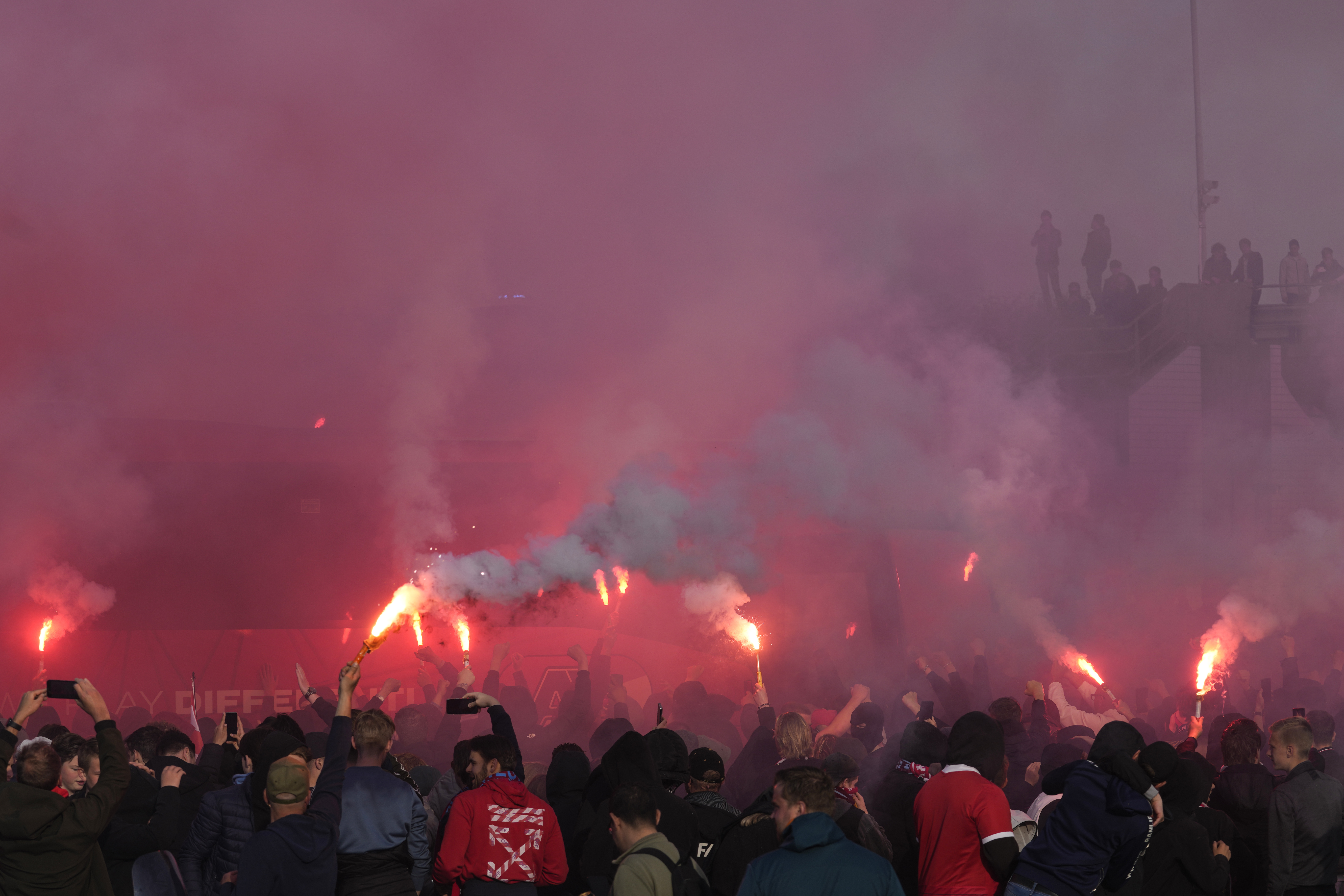 AZ supporters, some holding flares, meet the players' bus before the Conference League second leg semifinal soccer match between AZ Alkmaar and West Ham at the AZ stadium in Alkmaar, Netherlands, Thursday, May 18, 2023. (AP Photo/Peter Dejong)