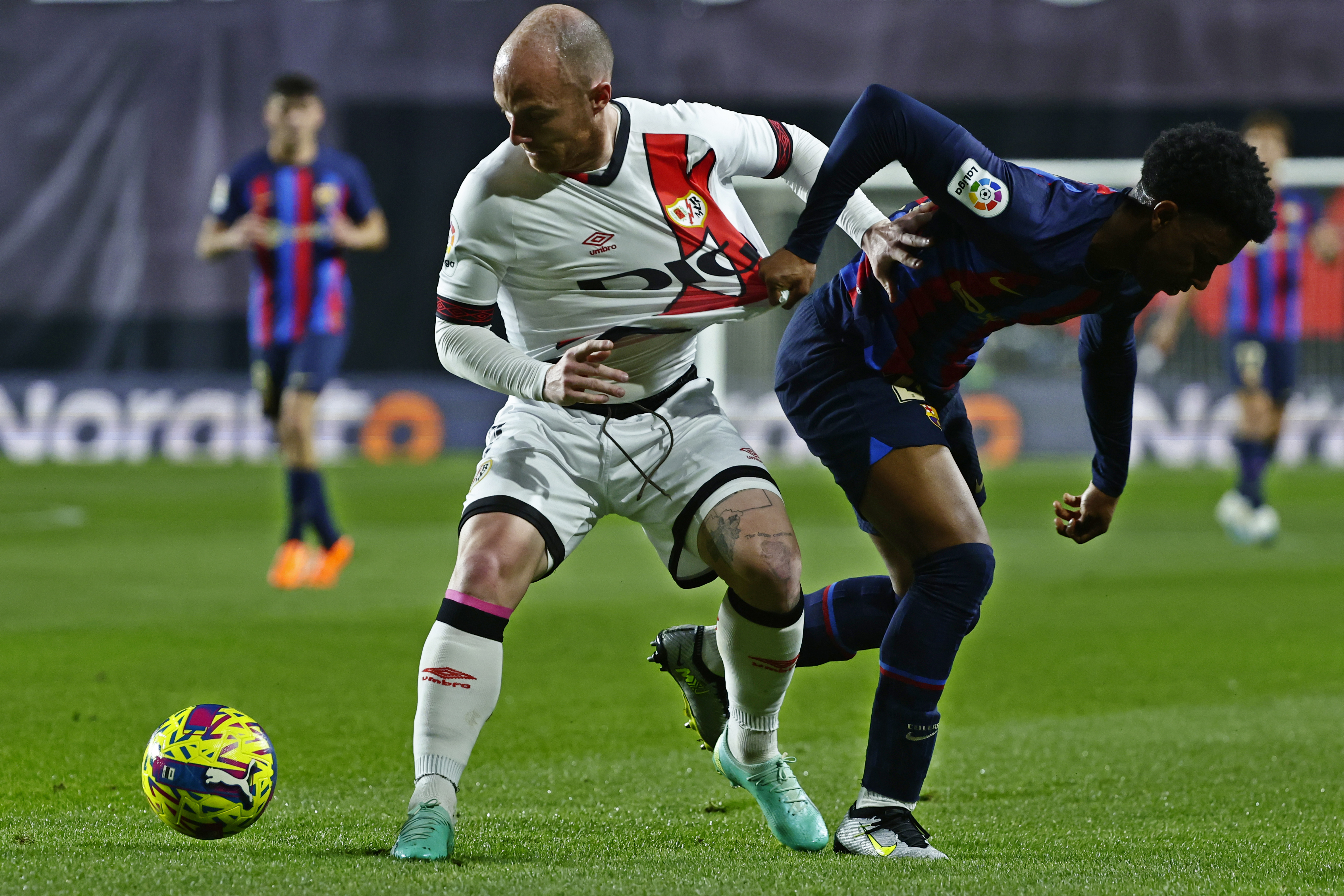 Rayo's Isi Palazon, left, challenges for the ball with Barcelona's Alejandro Balde during a Spanish La Liga soccer match between Rayo Vallecano and Barcelona at the Vallecas stadium in Madrid, Spain, Wednesday, April 26, 2023. (AP Photo/Pablo Garcia)