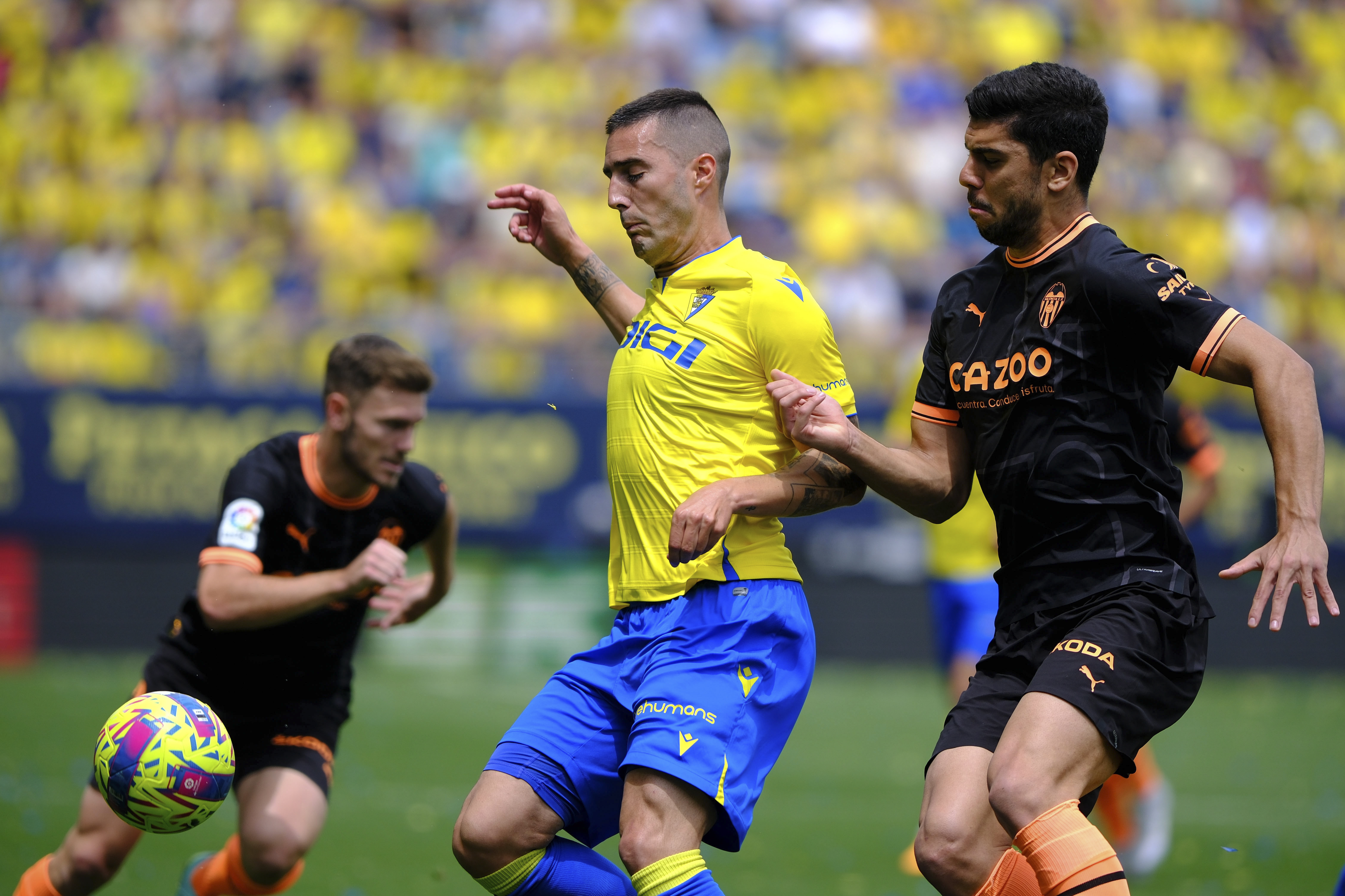 epa10600140 Cadiz CF's Sergi Guardiola (C) in action against Valencia CF's Cenk Ozkacar (R) during a Spanish LaLiga soccer match between Cadiz CF and Valencia CF at Nuevo Mirandilla stadium in Cadiz, southern Spain, 30 April 2023.  EPA-EFE/ROMAN RIOS