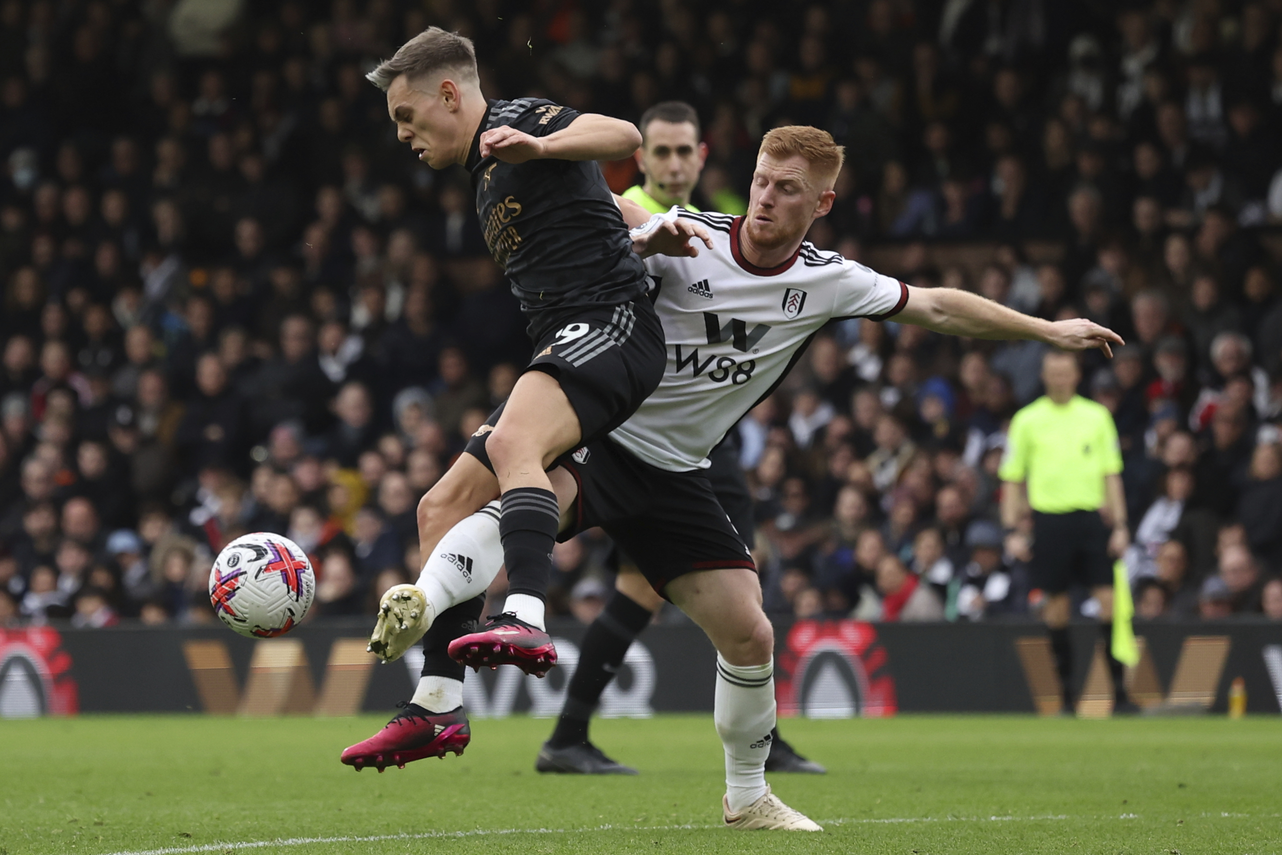 Arsenal's Leandro Trossard, left, duels for the ball with Fulham's Harrison Reed during the English Premier League soccer match between Fulham and Arsenal at Craven Cottage stadium in London, Sunday, March 12, 2023. (AP Photo/Ian Walton)