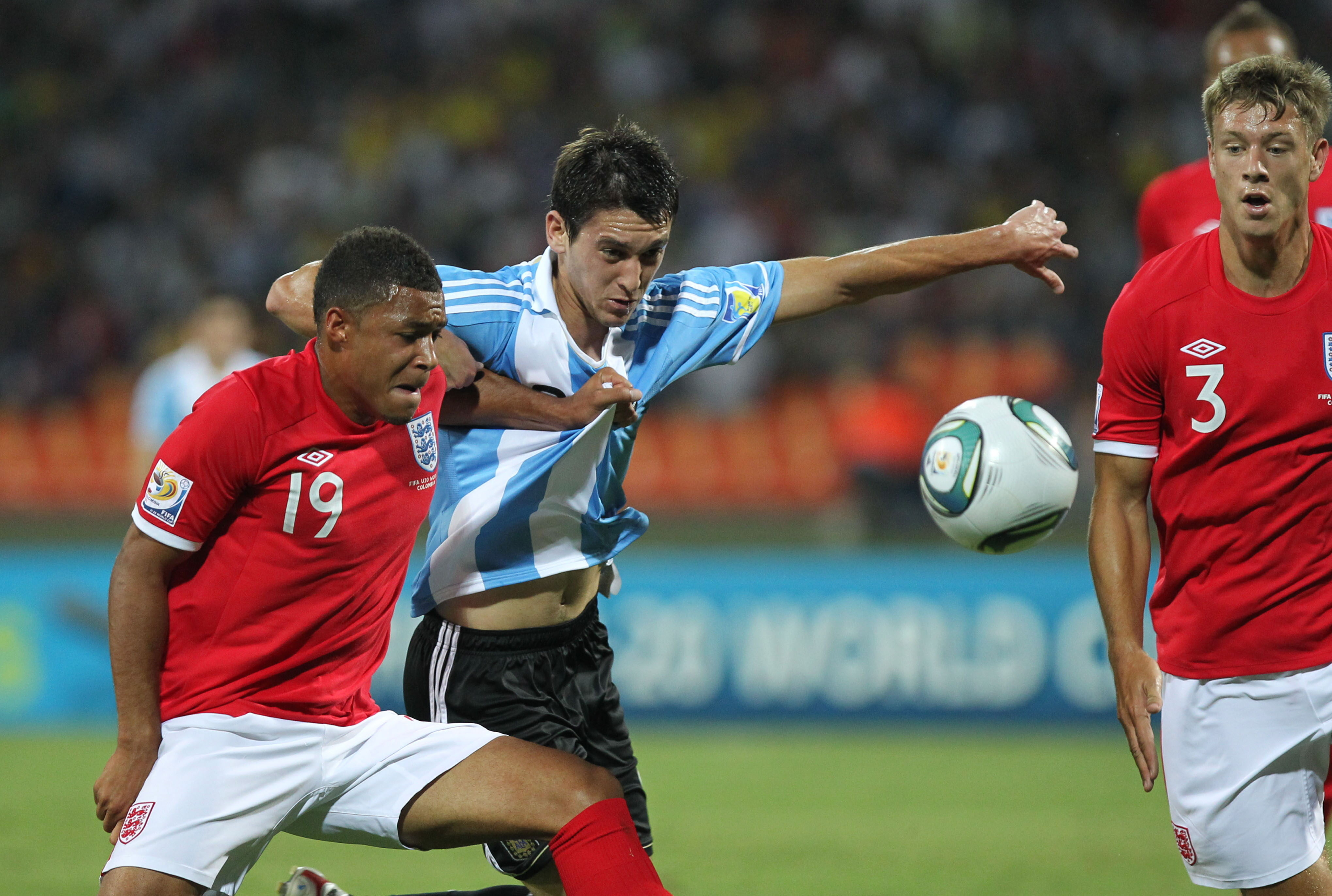 epa02852294 Argentina´s Facundo Ferreyra (C) fights for the ball with England´s Reece Wabara (L) and Nathan Baker (R) during a World Cup Under 20 match for the Group F at Atanasio Girardot in Medellin, Colombia, 01 August 2011.  EPA/Mauricio Duenas