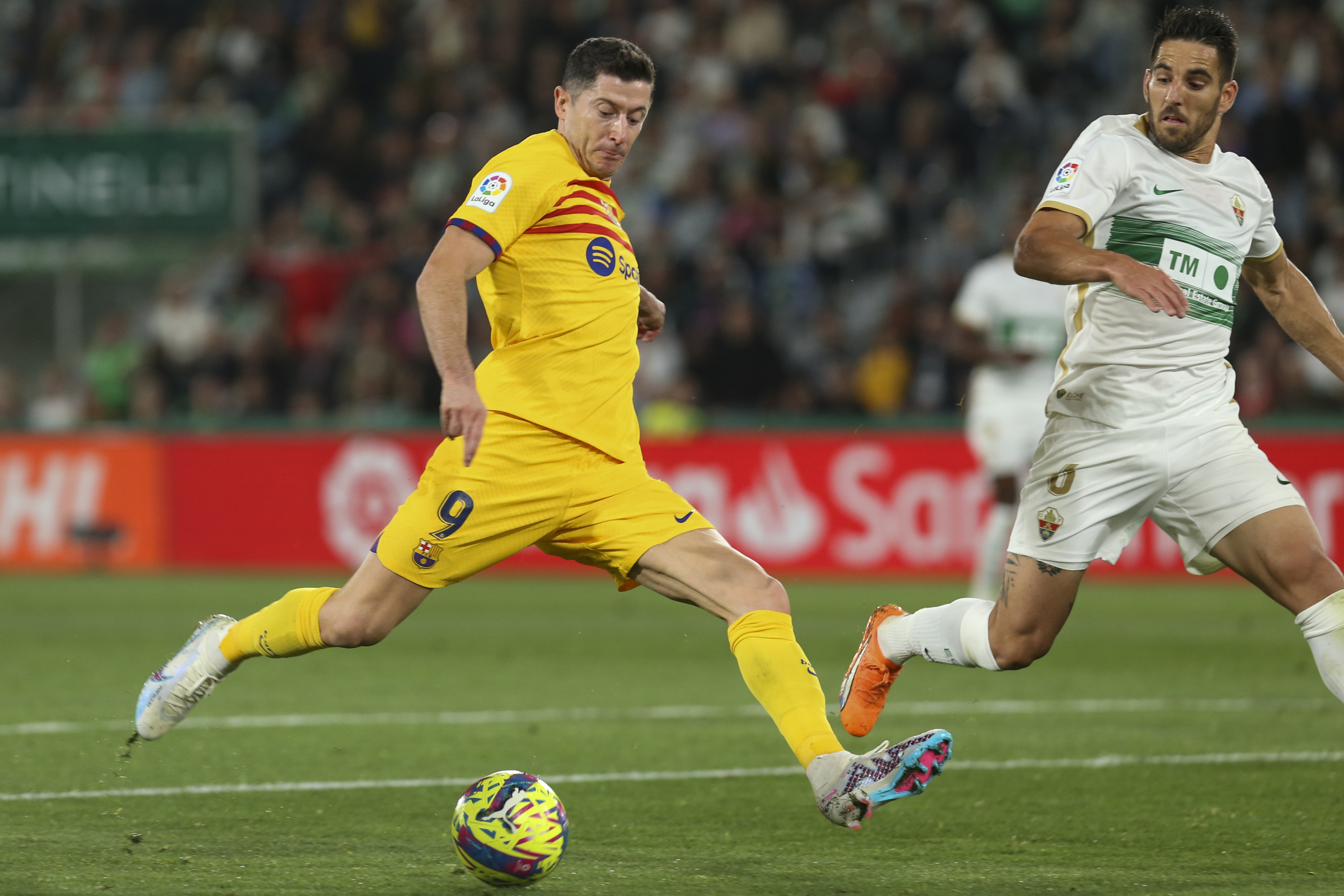 Barcelona's Robert Lewandowski, front, scores his side's third goal during a Spanish La Liga soccer match between Elche and Barcelona, at the Martinez Valero Stadium in Elche, Spain, Saturday, April 1, 2023. (AP Photo/Alberto Saiz)