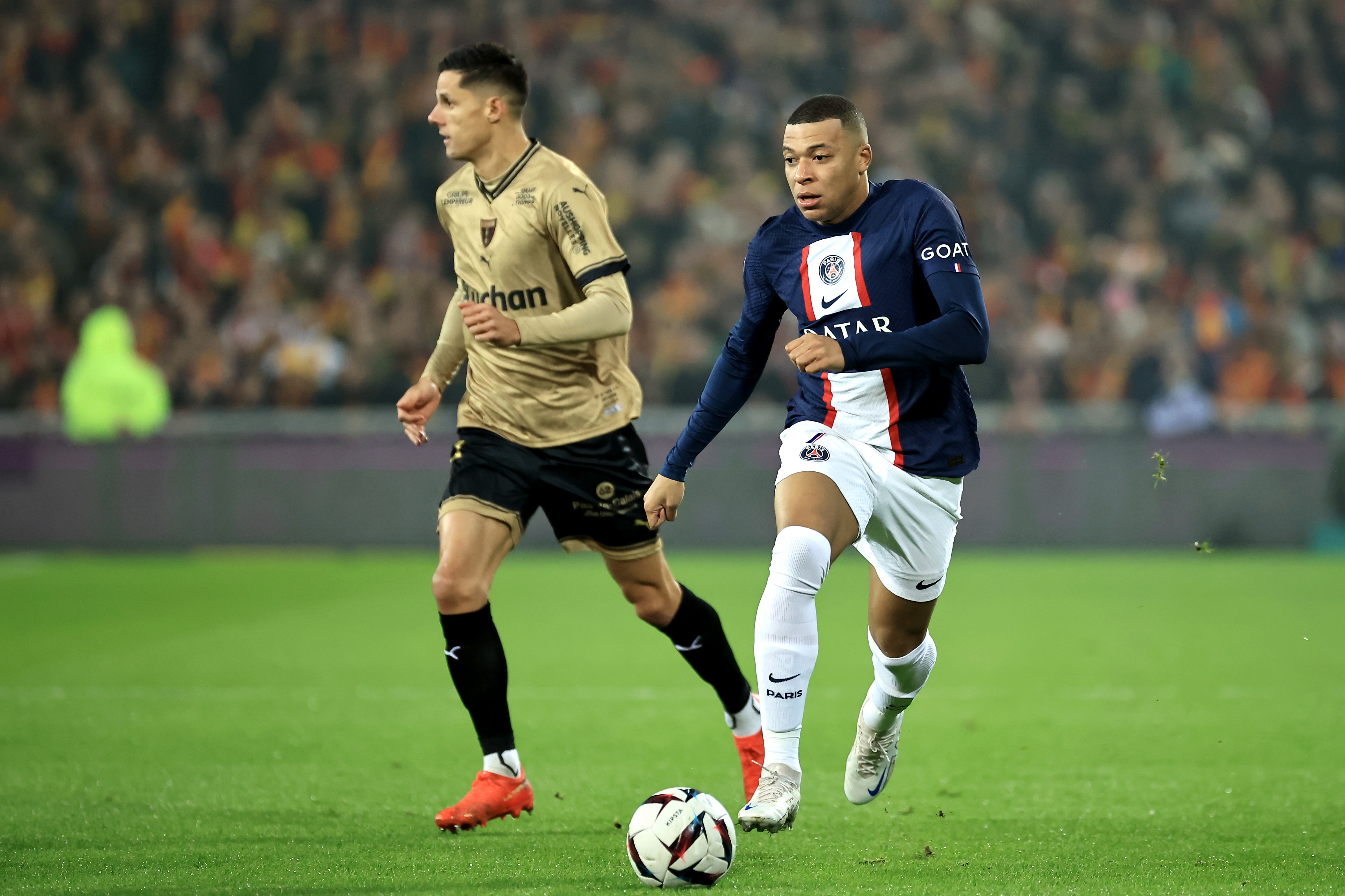 epa10385760 Paris Saint Germain's Kylian Mbappe (R) in action during the French Ligue 1 soccer match between RC Lens and Paris Saint Germain in Lens, France, 01 January 2023.  EPA-EFE/CHRISTOPHE PETIT TESSON