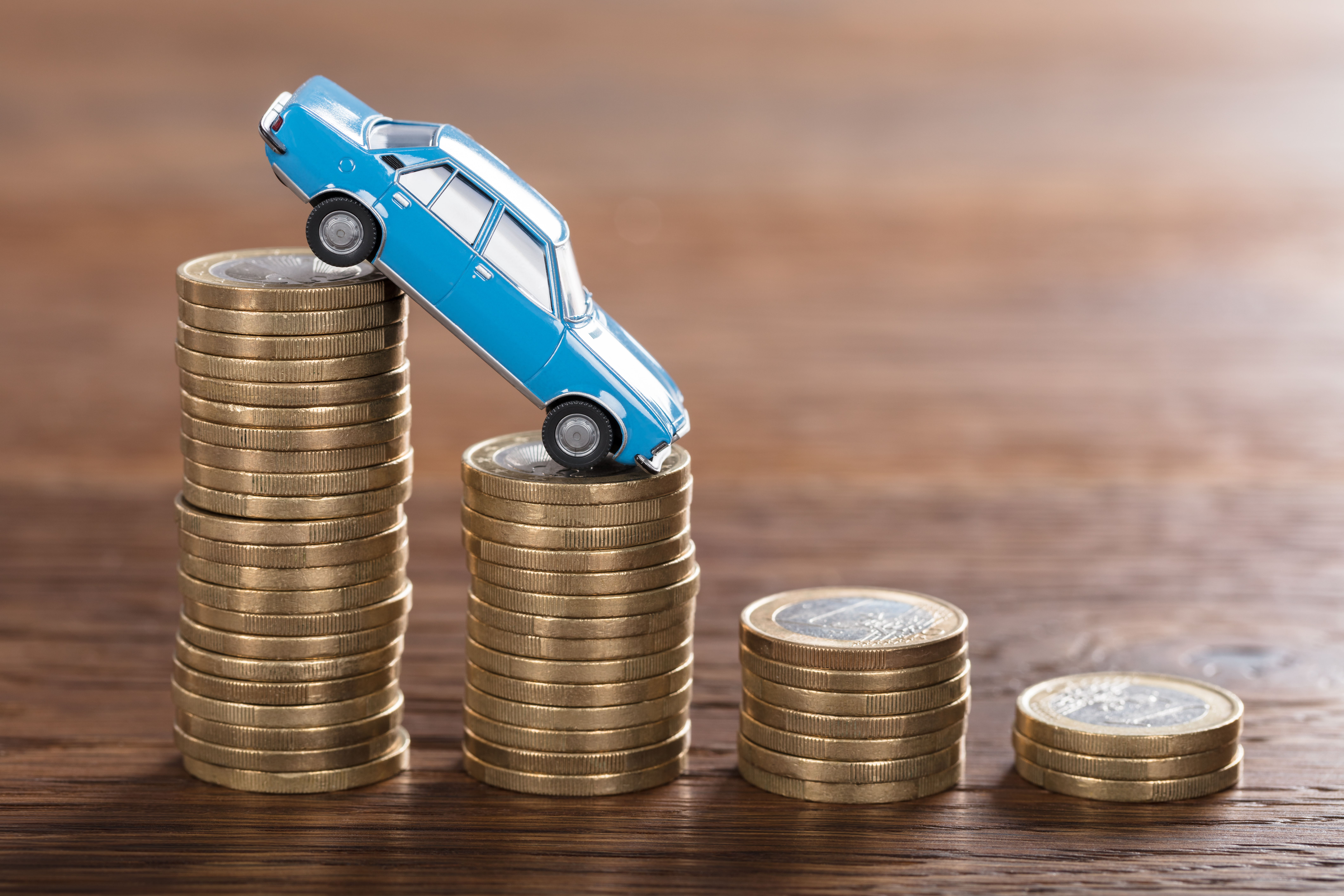 Close-up,Of,A,Car,Model,Over,A,Stacked,Coin,At