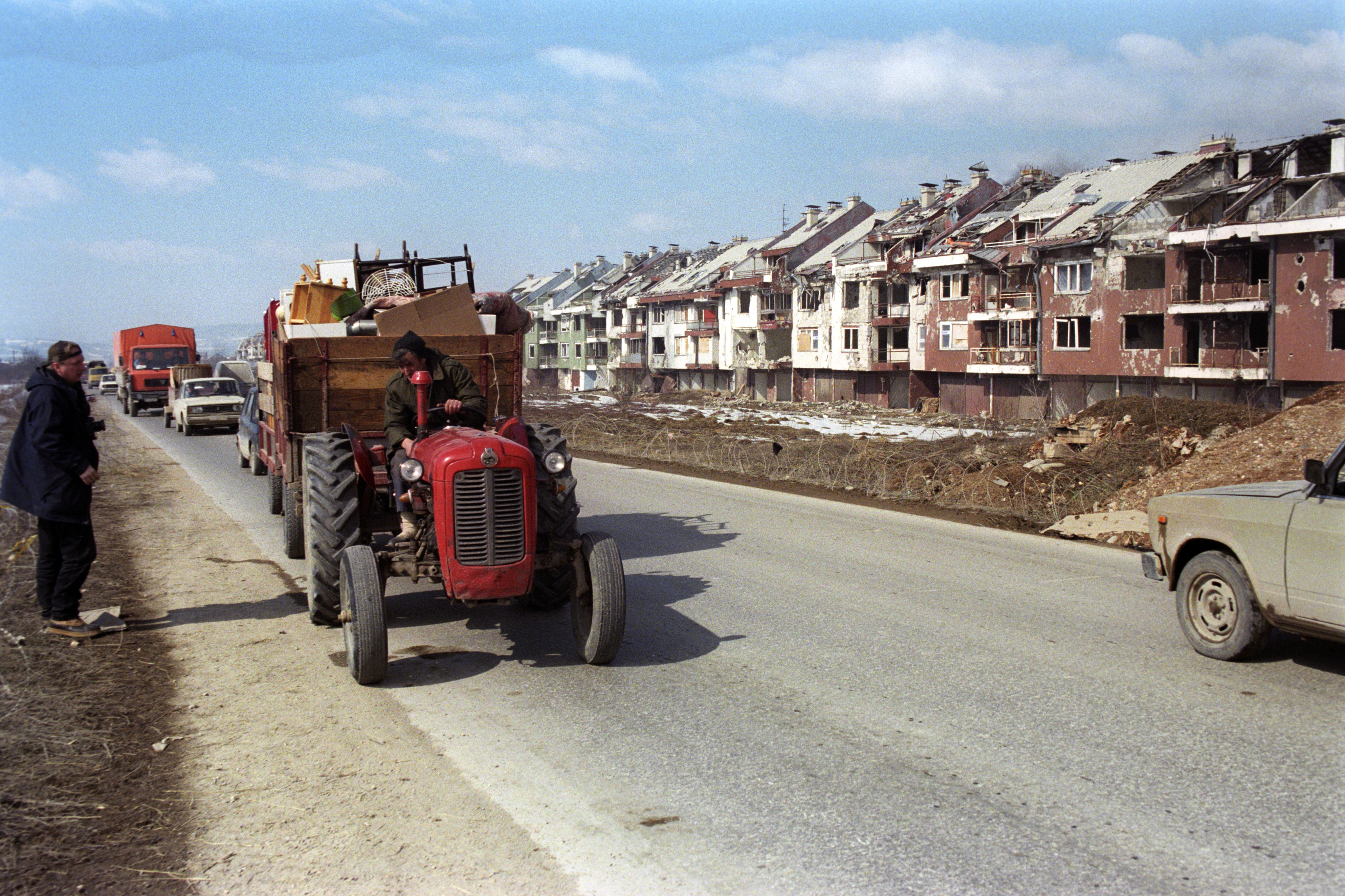 A caravan of vehicles, carrying belongings and people displaced during the siege of the city, passes a row of partially destroyed homes as they rey to Sarajevo, Bosnia and Hercegovina, 07 March 1996 to re-start their lives
 EPA/FEHIM DEMIR