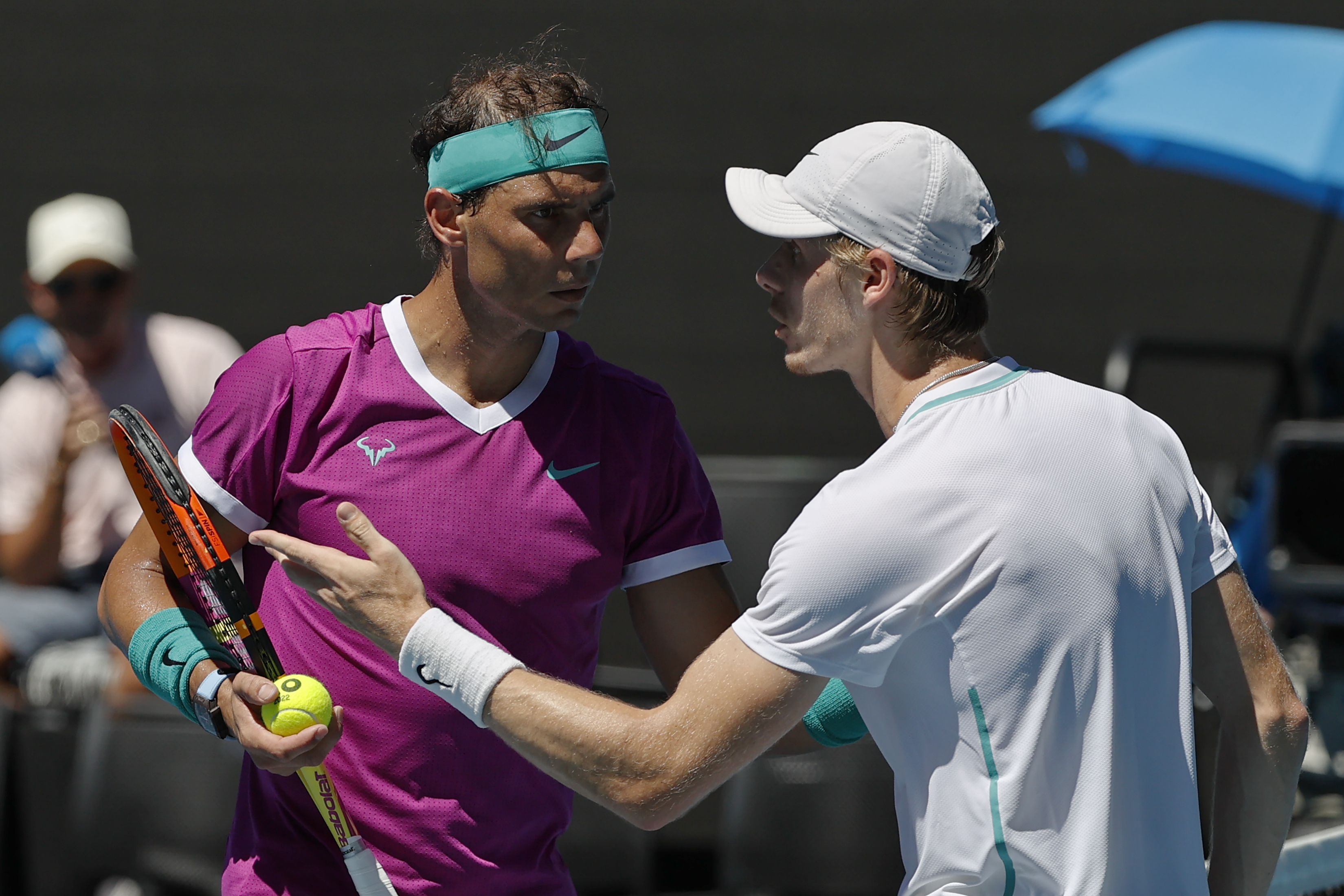 Denis Shapovalov of Canada talks with Rafael Nadal, left, of Spain during their quarterfinal match at the Australian Open tennis championships in Melbourne, Australia, Tuesday, Jan. 25, 2022. (AP Photo/Tertius Pickard)