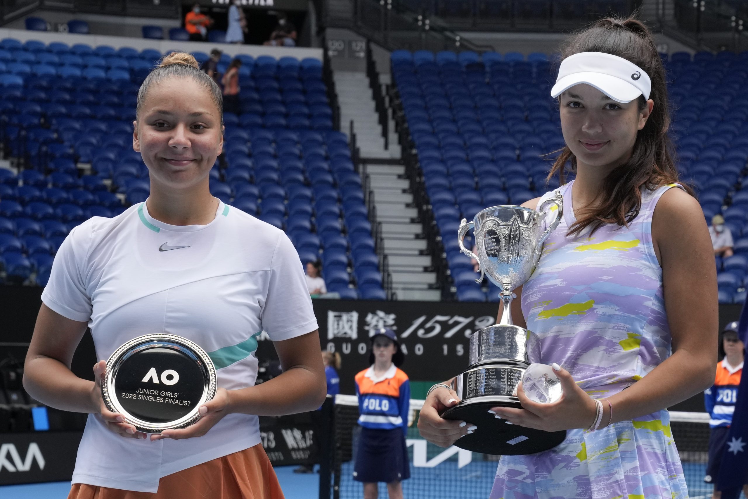 Petra Marcinko, right, of Croatia holds her trophy aloft after defeating Sofia Costoulas of Belgium in the girls' singles final at the Australian Open tennis championships in Melbourne, Australia, Saturday, Jan. 29, 2022. (AP Photo/Mark Baker)
