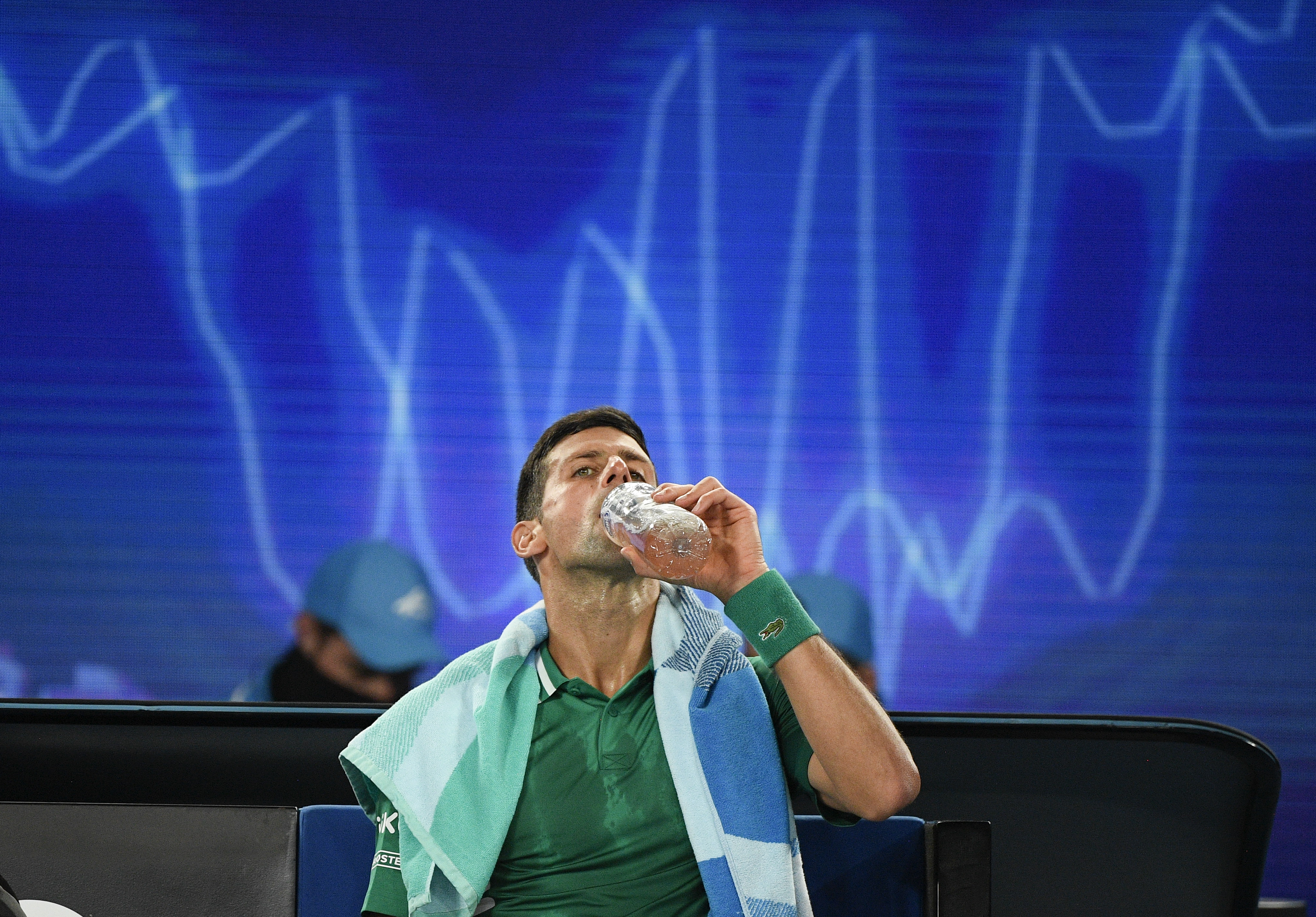 Serbia's Novak Djokovic takes a drink during a break in his quarterfinal against Germany's Alexander Zverev at the Australian Open tennis championship in Melbourne, Australia, Tuesday, Feb. 16, 2021.(AP Photo/Andy Brownbill)