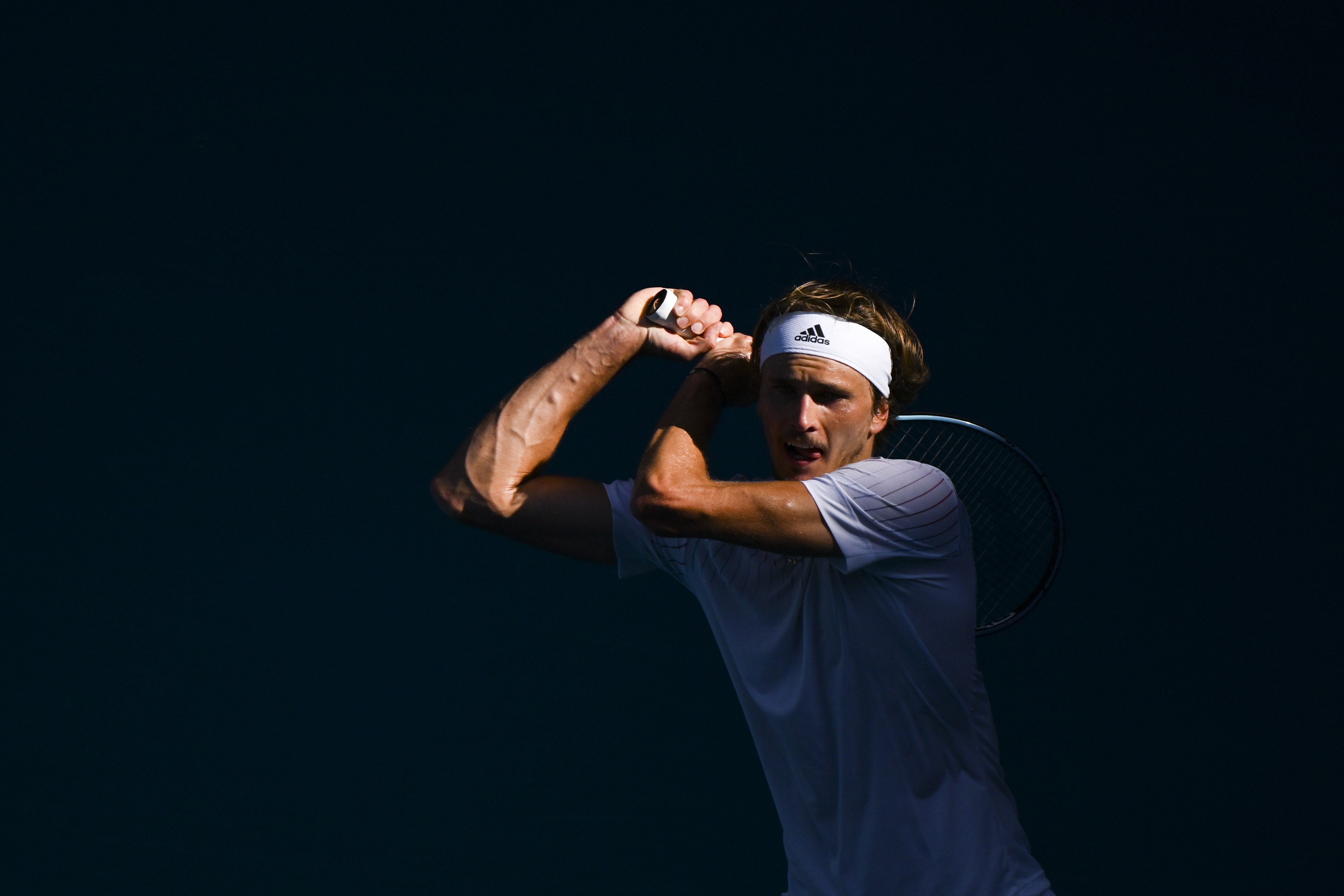 epa09703544 Alexander Zverev of Germany returns to Denis Shapovalov of Canada in their fourth round match during the Australian Open Grand Slam tennis tournament in Melbourne, Australia, 23 January 2022.  EPA-EFE/DEAN LEWINS  AUSTRALIA AND NEW ZEALAND OUT