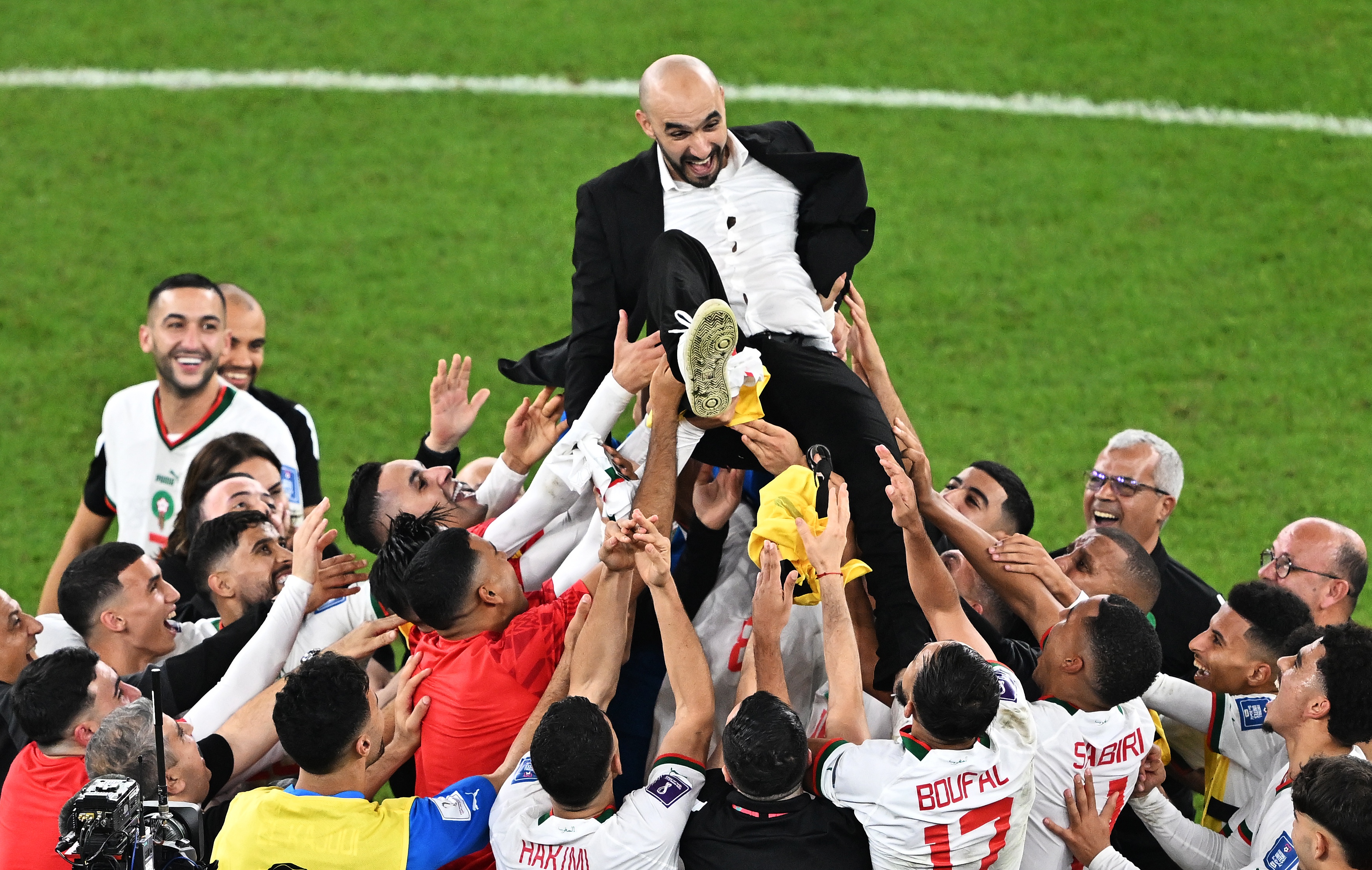 epa10342098 Head coach Walid Regragui of Morocco is celebrated by his team after they won the FIFA World Cup 2022 group F soccer match between Canada and Morocco at Al Thumama Stadium in Doha, Qatar, 01 December 2022.  EPA-EFE/Noushad Thekkayil